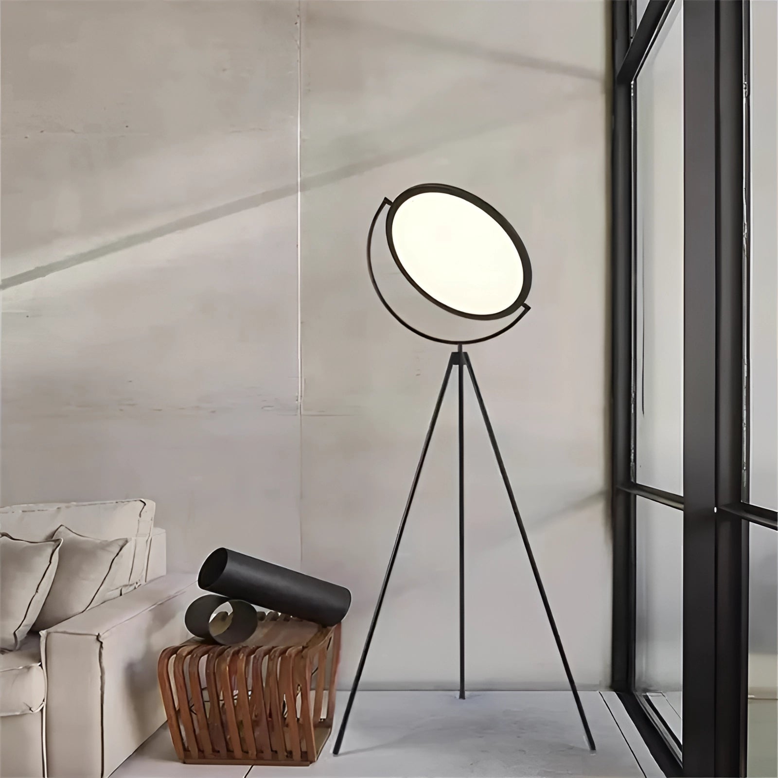Modern black tripod floor lamp with adjustable design, featuring a sleek minimalist style in an elegant interior setting with wood flooring and large windows.