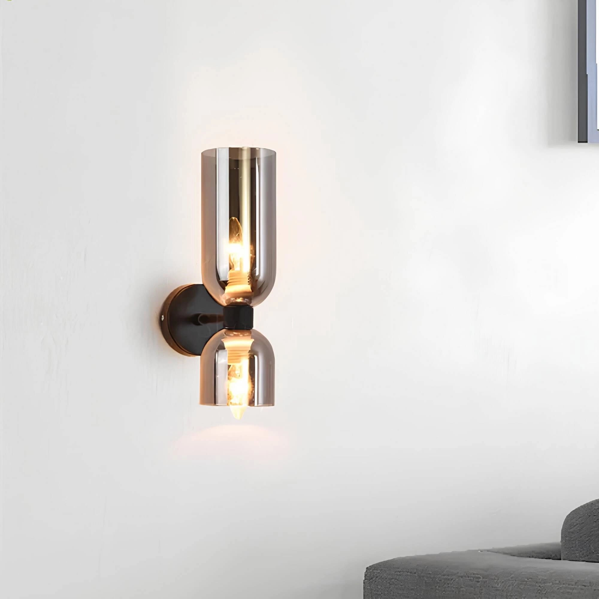 Modern blue glass wall sconce with brass accent mounted on a wall, featuring a sleek rectangular design and illuminated light fixture.