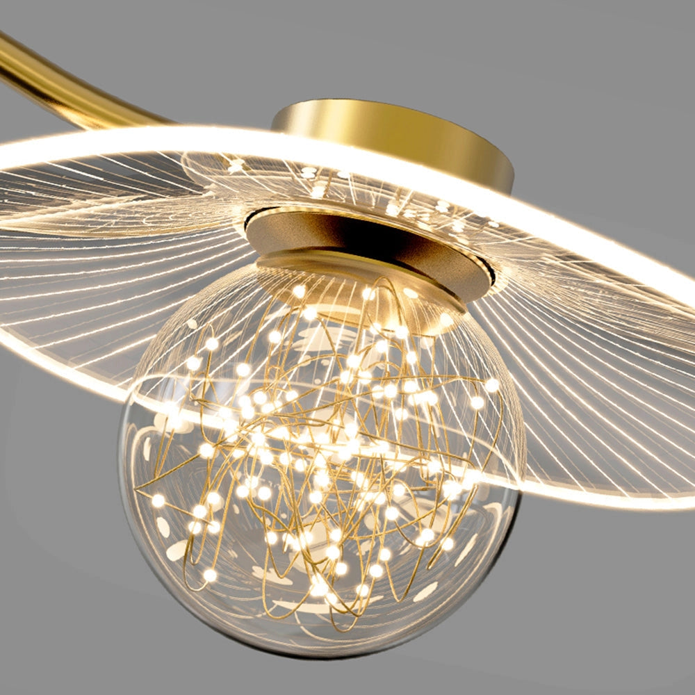 Modern brass chandelier with glass globe pendant lights, featuring a warm amber and gold tint, hanging as a ceiling fixture.