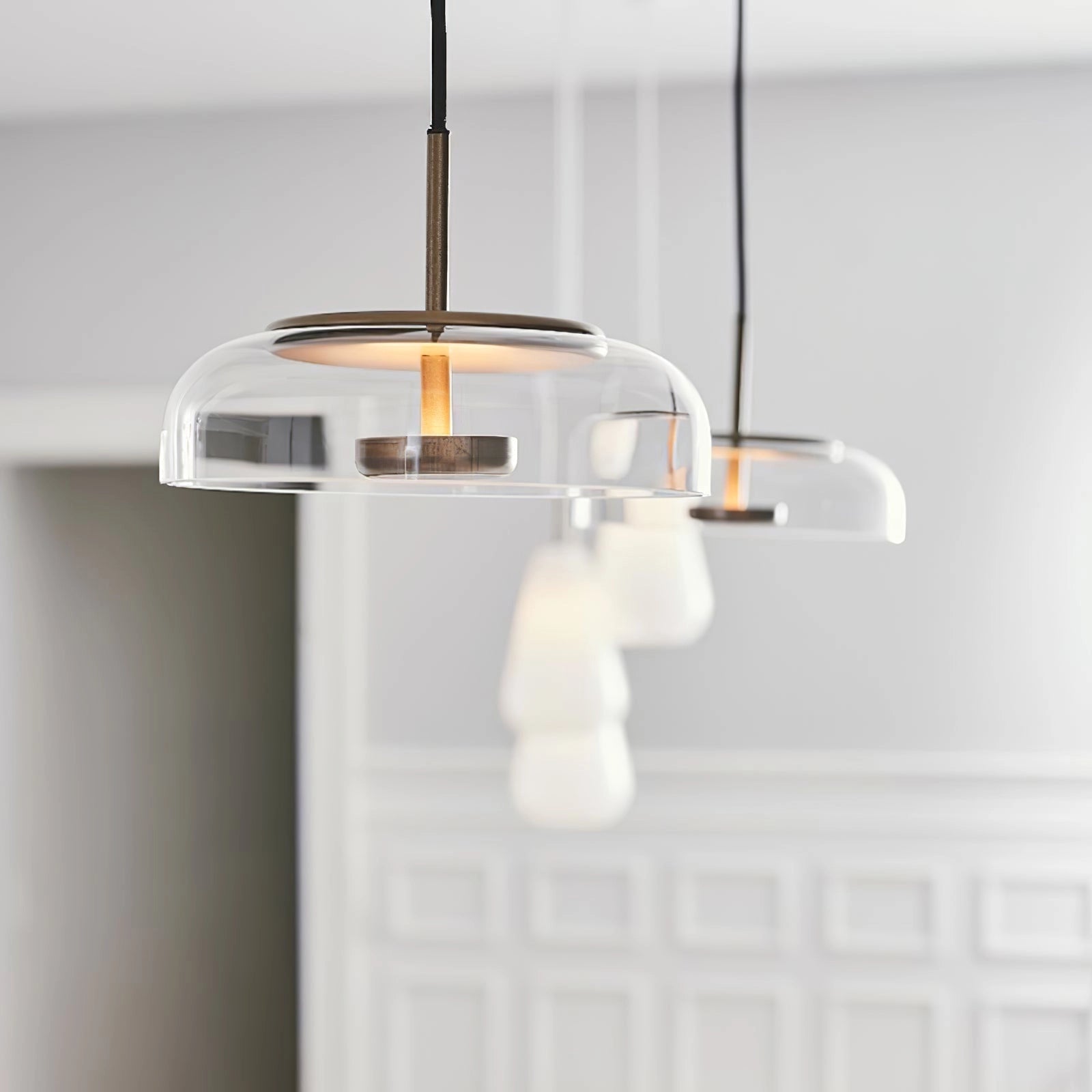 Modern brass and chrome LED pendant lights with a minimalist design, featuring a sleek metal and glass construction, hanging from the ceiling as a luxurious interior light fixture.