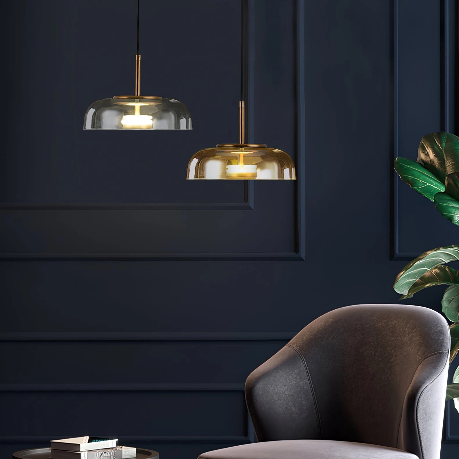 Modern brass and chrome LED pendant lights hanging above a minimalist setting with comfortable green chairs, wood flooring, and ambient lighting.