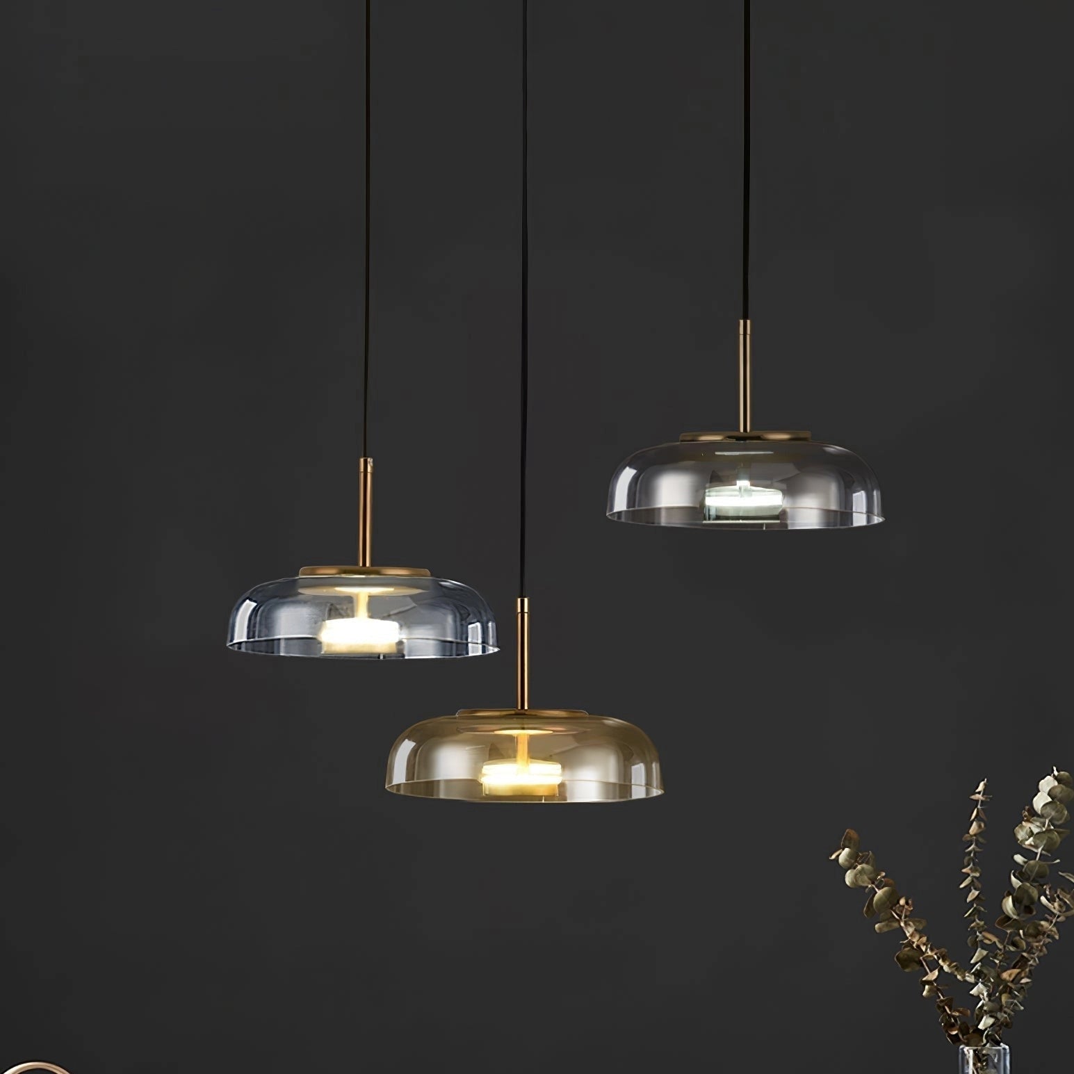 Modern brass and chrome LED pendant lights with minimalist design, hanging from the ceiling.