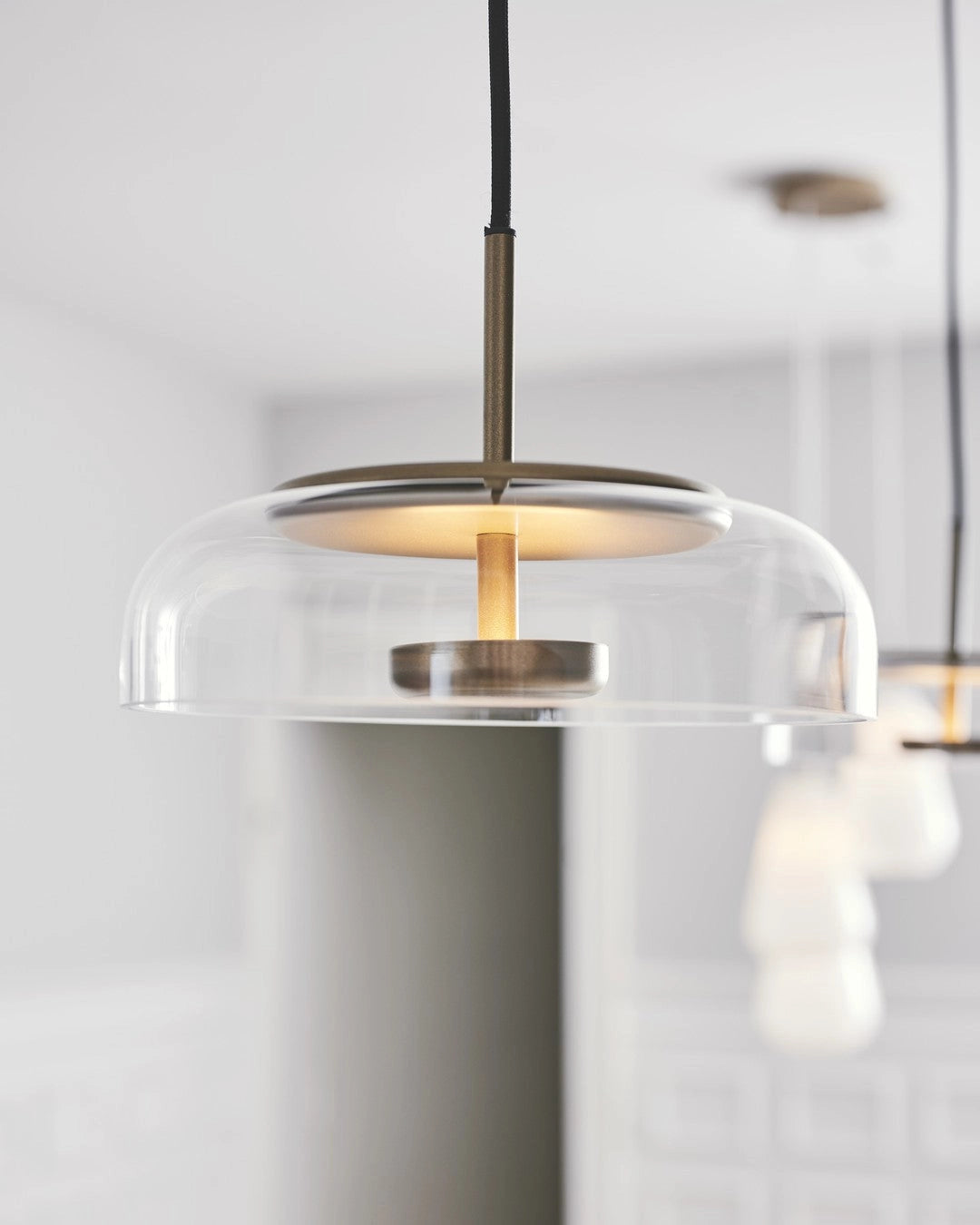 Modern brass and chrome LED pendant lights with minimalist design, featuring transparent glass cylindrical fixtures.