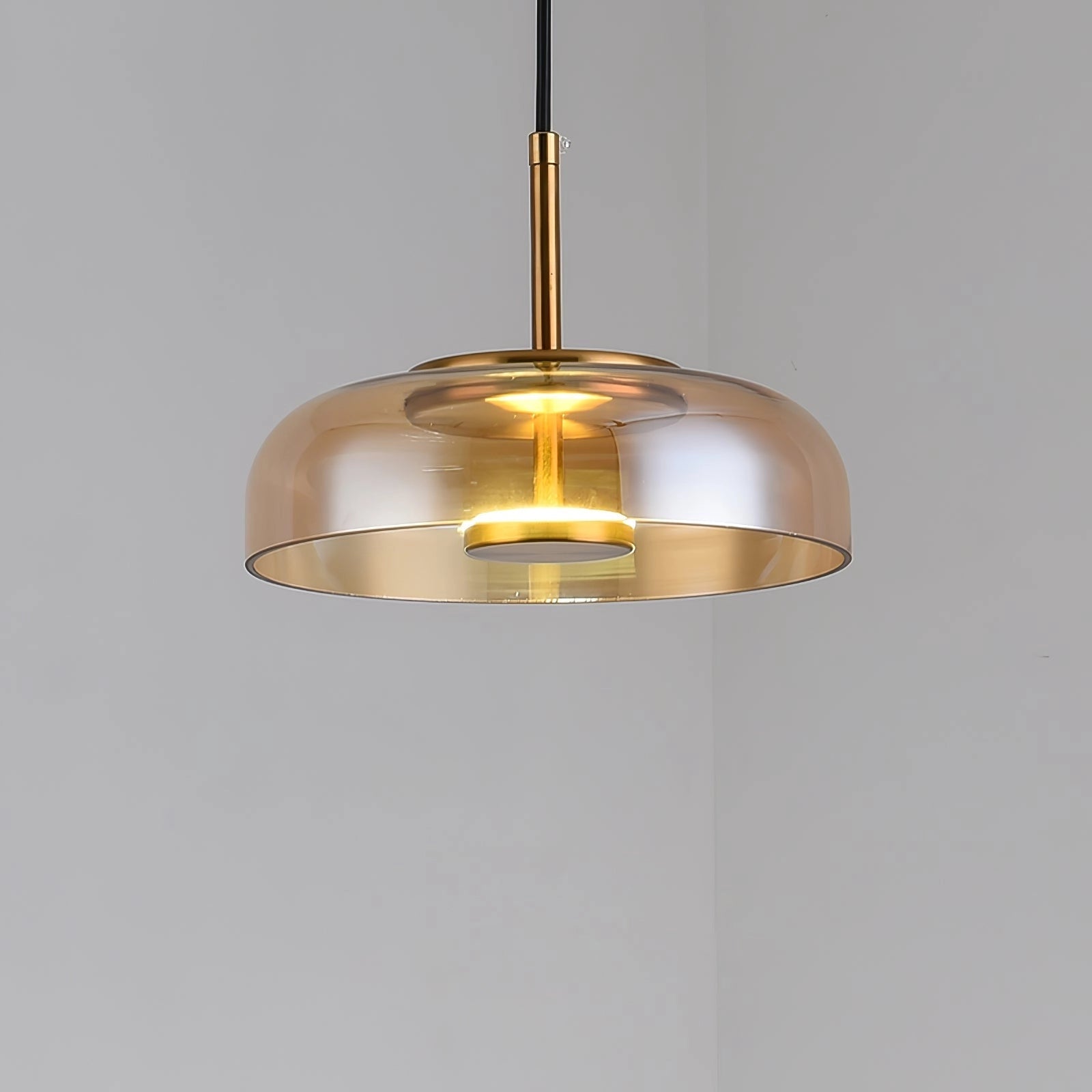 Modern brass and chrome LED pendant lights with a minimalist design, featuring circular metal fixtures hanging from the ceiling.