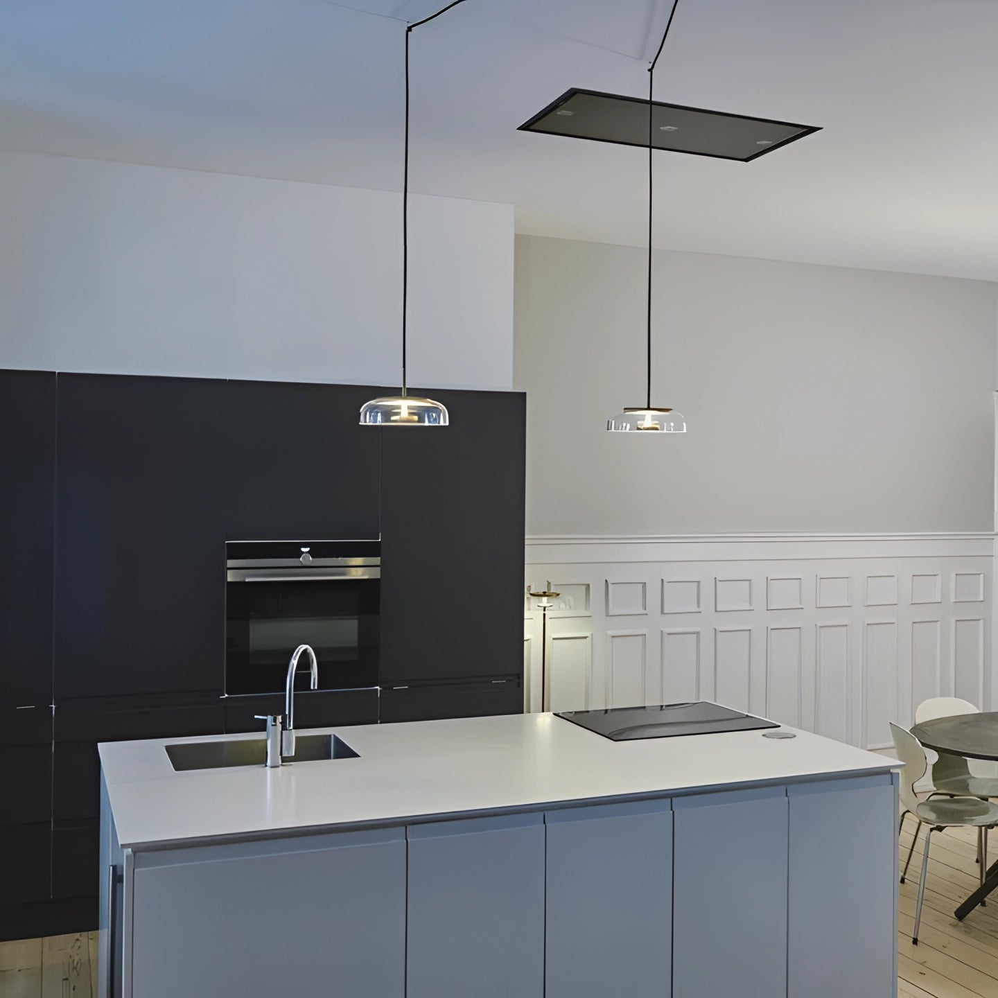 Modern kitchen with cabinetry, countertop, and sink featuring luxury minimalist brass and chrome LED pendant lights hanging above.