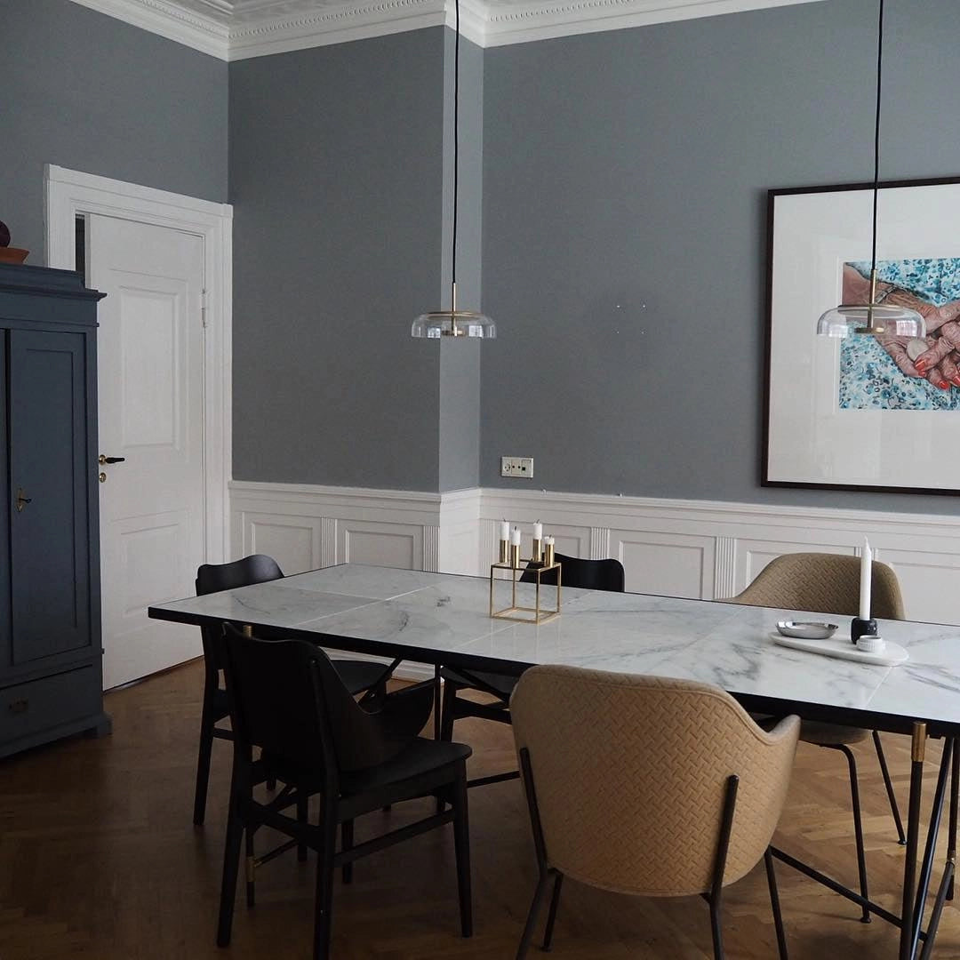 Modern Brass and Chrome LED Pendant Lights hanging above a wooden table and chairs in a stylish interior design setting.