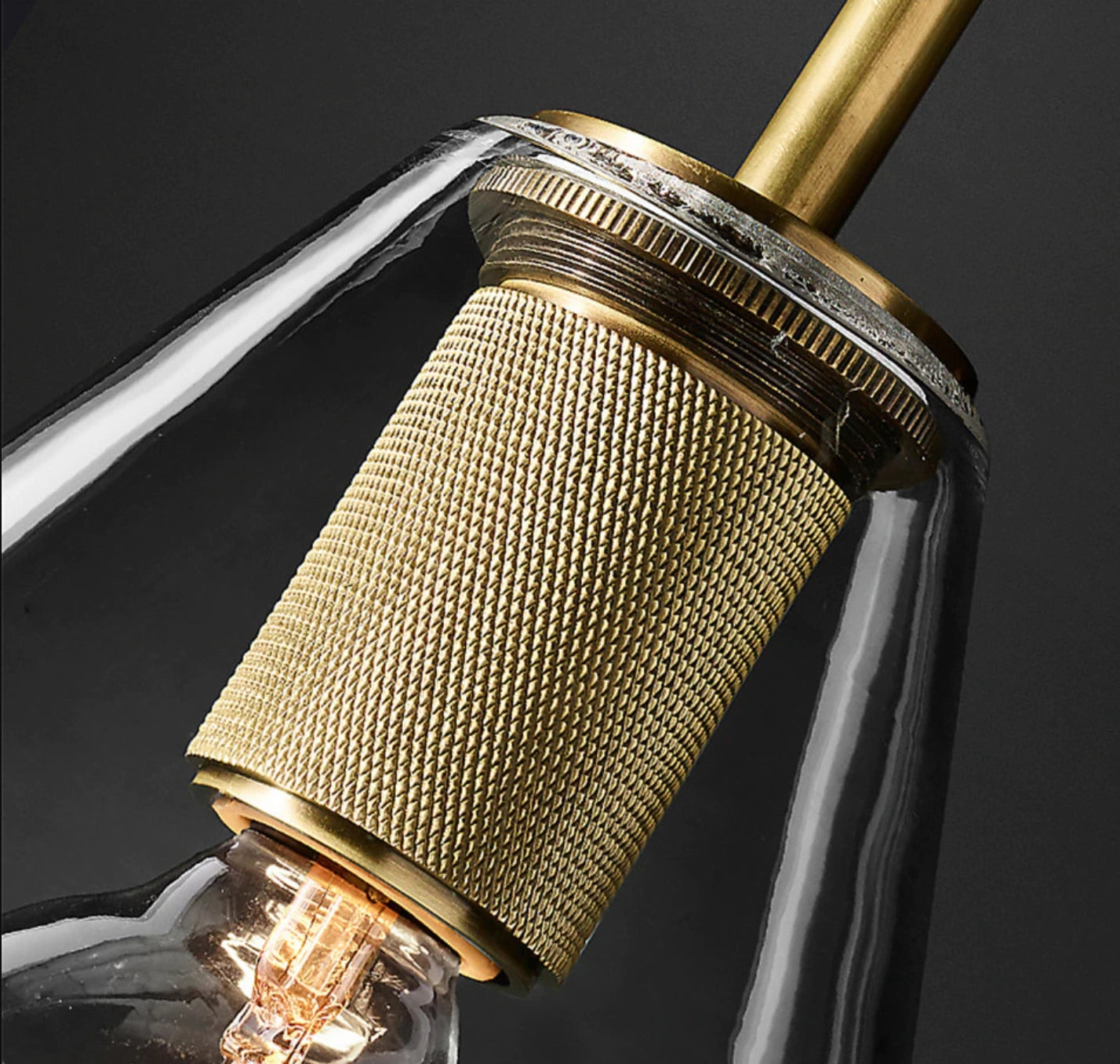Modern brass dual bulb wall sconce with triangle glass shade featuring a sleek metal design.
