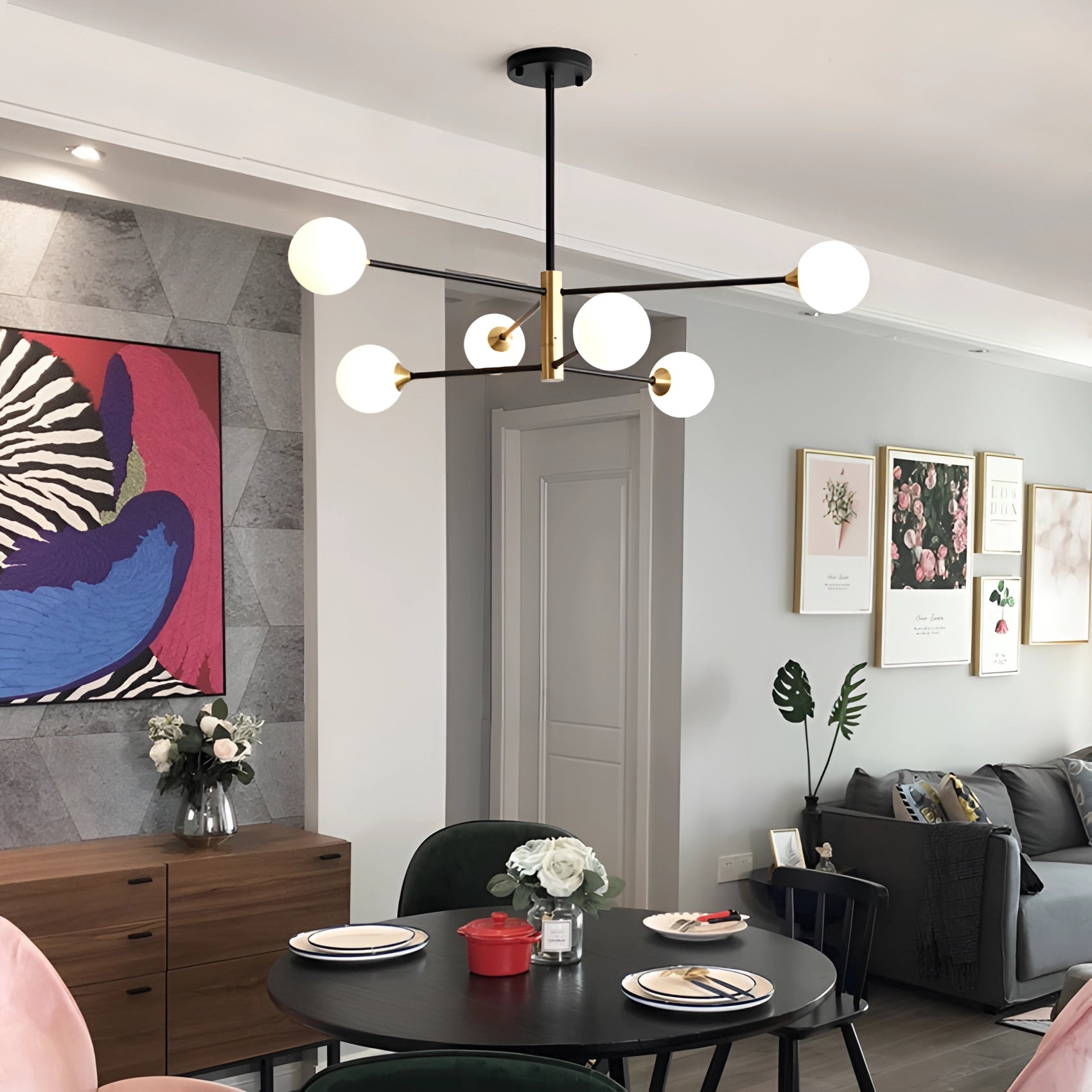 Modern brass geometric LED chandelier with mid-century minimalist design hanging in a stylish living room featuring a couch, wooden floor, and contemporary furniture.