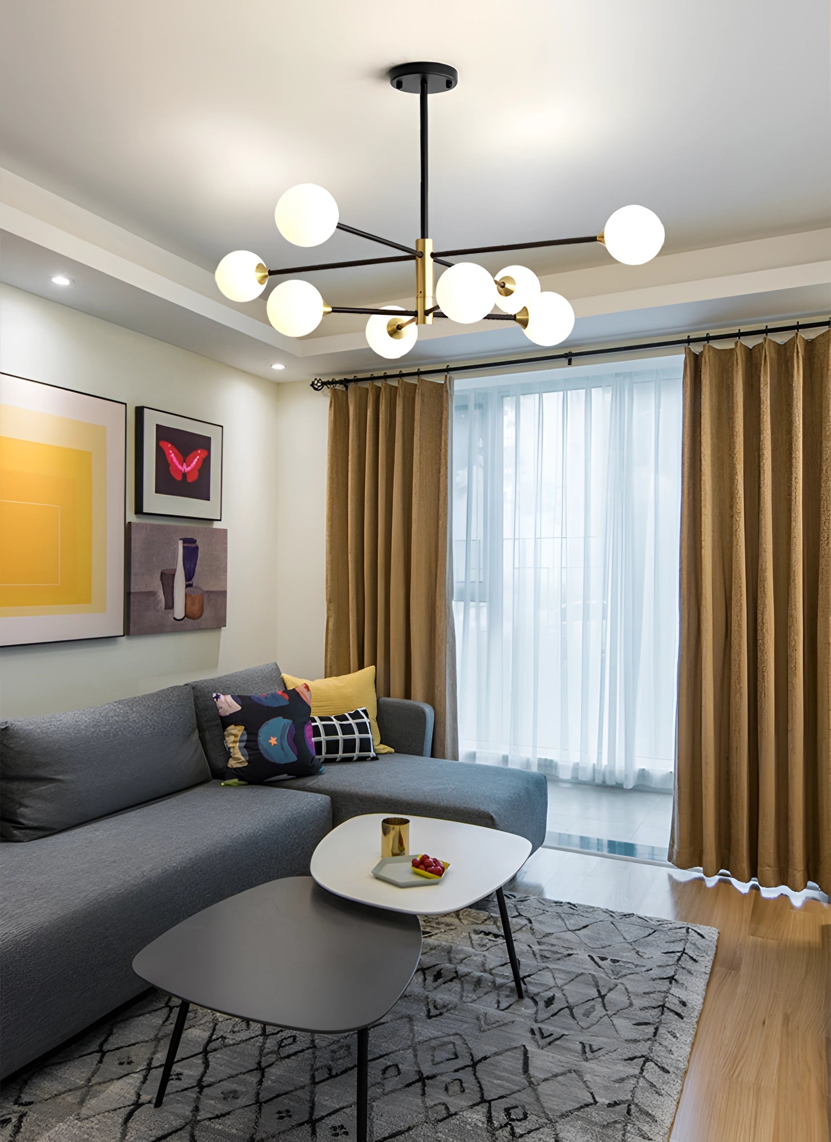 Modern brass geometric LED chandelier with mid-century minimalist design, illuminating a stylish living room with a couch, table, and wooden flooring.