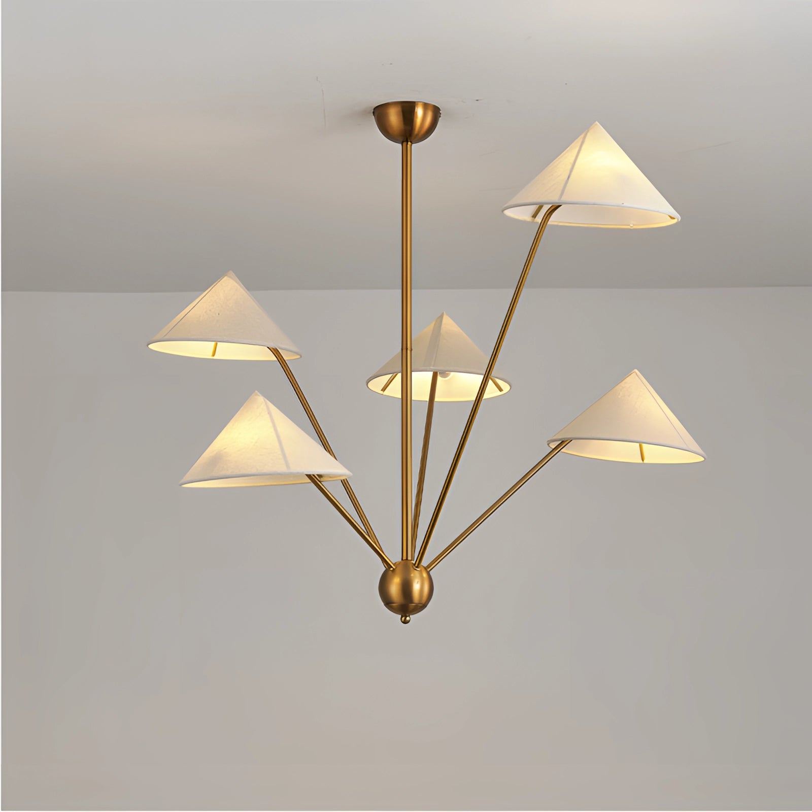 Modern brass geometric pendant chandelier with a mid-century minimalist design, featuring a symmetrical arrangement of triangular and rectangular elements in amber and wood tones, suspended from the ceiling.