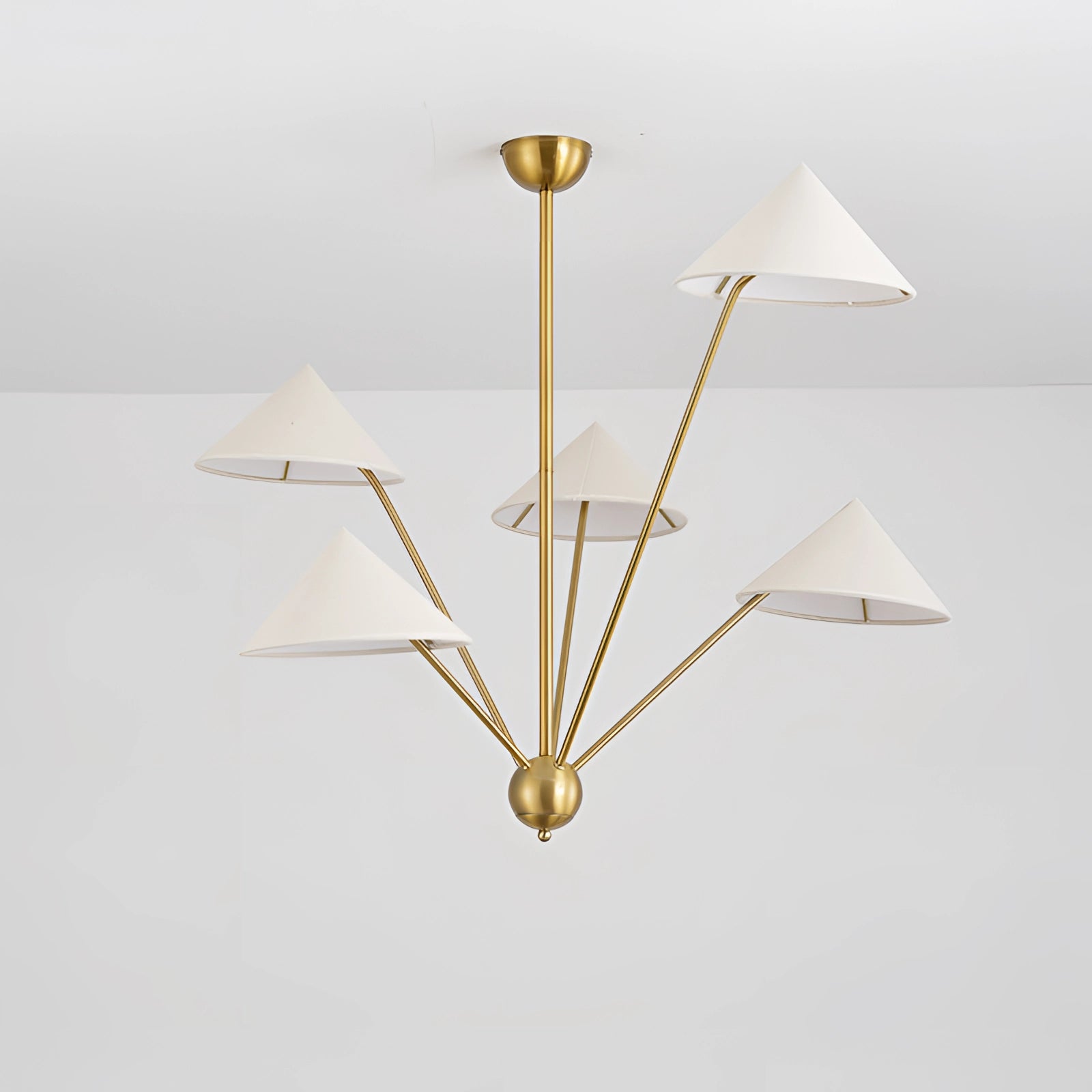 Modern brass geometric pendant chandelier hanging from the ceiling with a minimalist mid-century design, showcasing metal accents and a distinctive triangular shape.