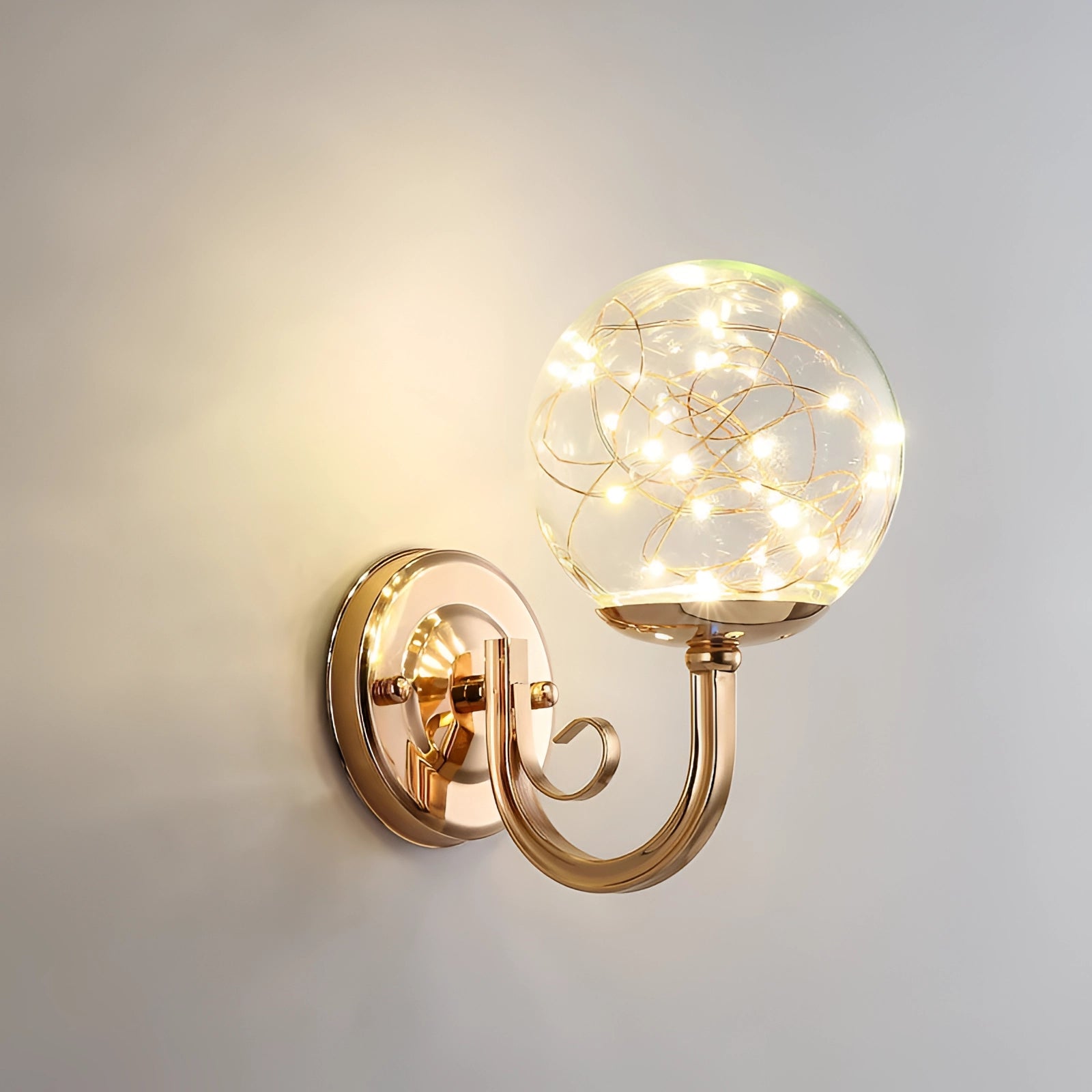 Modern brass glass globe LED wall sconce with an elegant design featuring a circular amber-colored glass shade and metallic elements, creating a stylish and artistic lighting fixture.