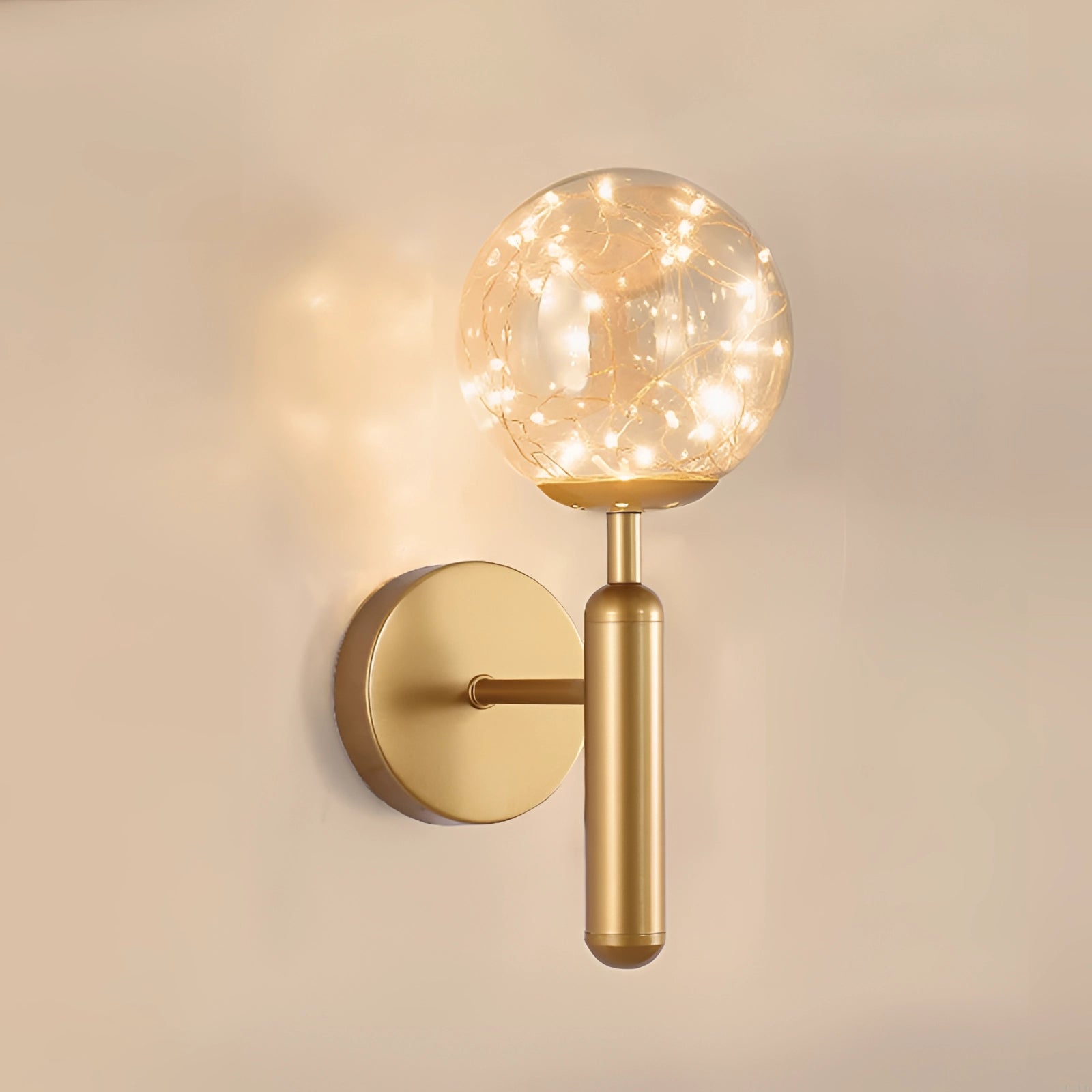 Modern brass glass globe LED wall sconce with an amber hue, featuring a circular design and wood accents, elegantly mounted on a wall as a decorative lighting fixture.