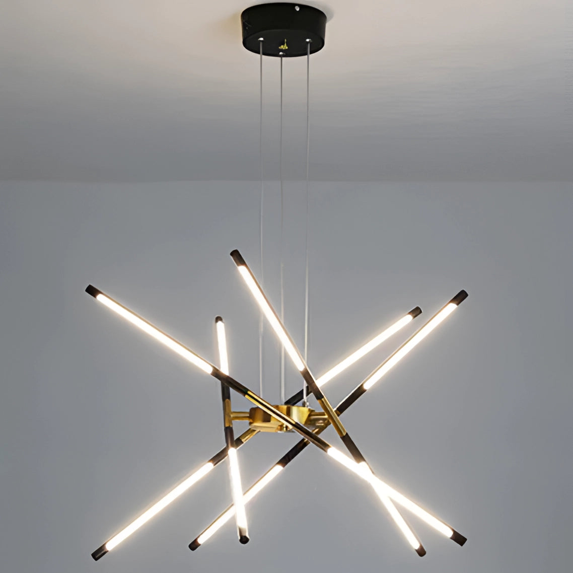 Modern brass LED chandelier with multiple arms and warm lighting, hanging in an elegantly decorated dining room.