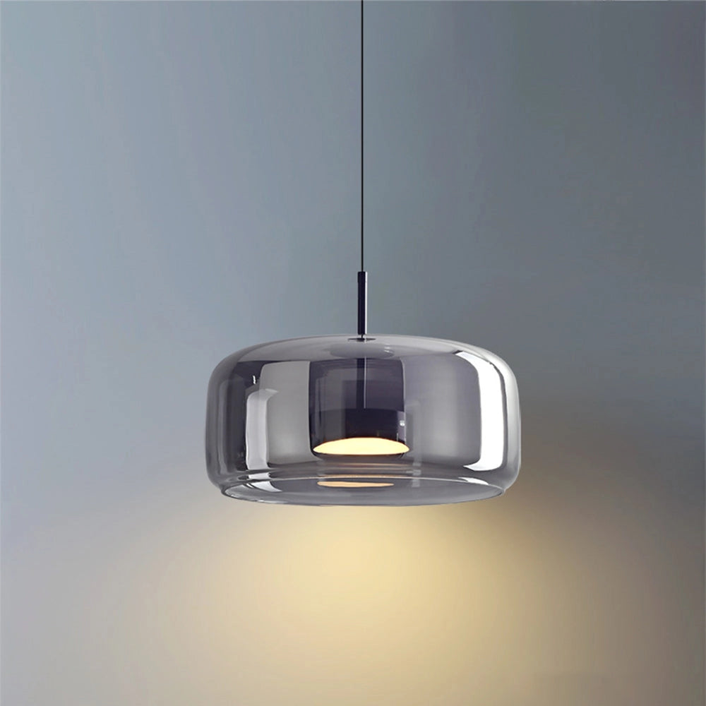 Modern brushed brass glass pendant light fixture hanging from the ceiling, featuring a sleek and contemporary design suitable for kitchens and dining areas. The fixture showcases a combination of metal and glass components, creating an elegant and stylish appearance.