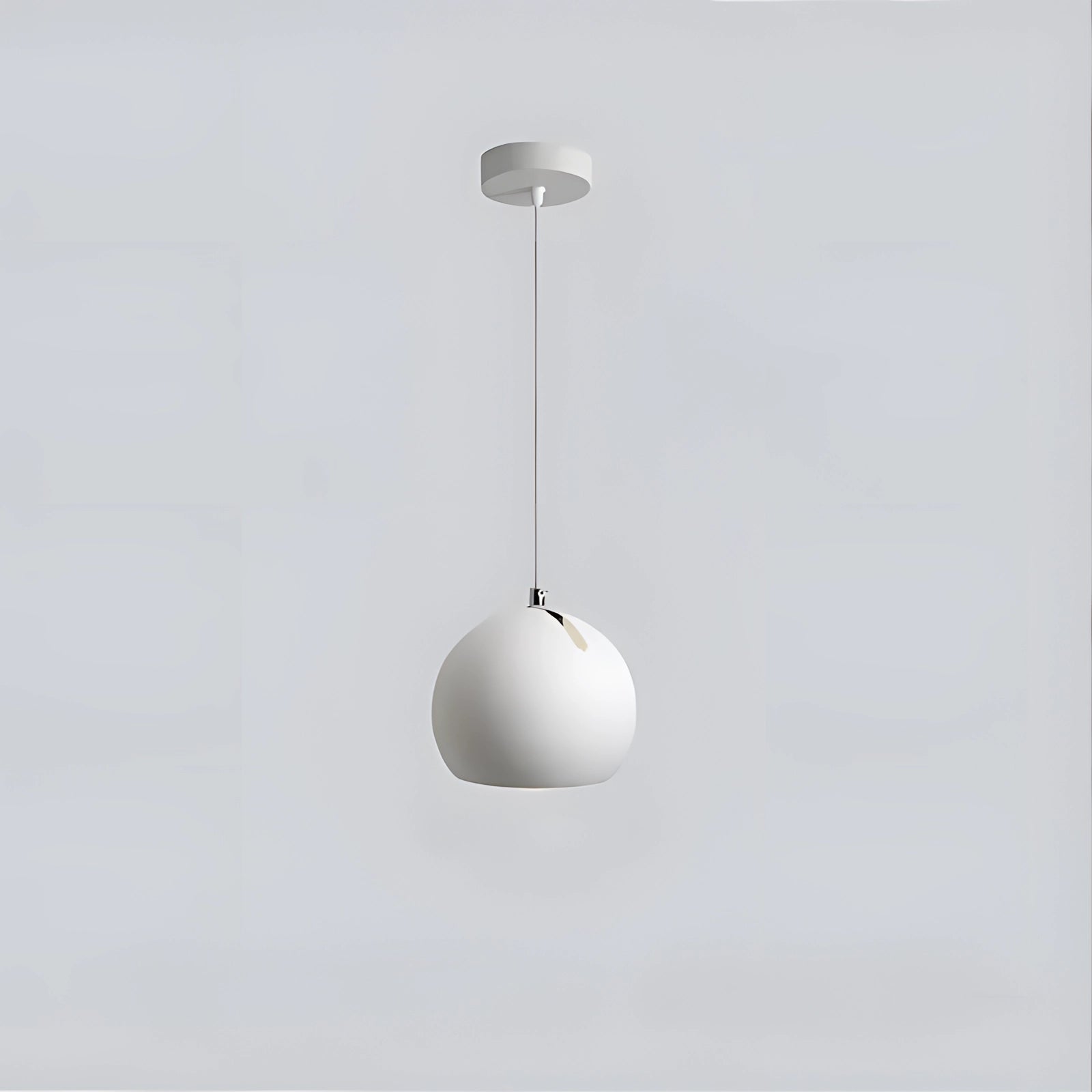 Modern ceramic globe pendant light in white, featuring a smooth circular design with an adjustable fixture. The pendant provides warm white lighting, ideal for luxury interior settings. The light hangs elegantly from the ceiling, showcasing a minimalist and stylish look.