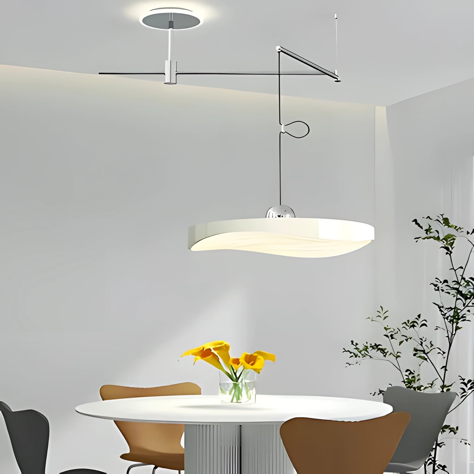 Modern circular LED pendant light in white, 50cm, hanging over a contemporary kitchen setup featuring a table, chairs, and a potted plant, showcasing a stylish interior design.