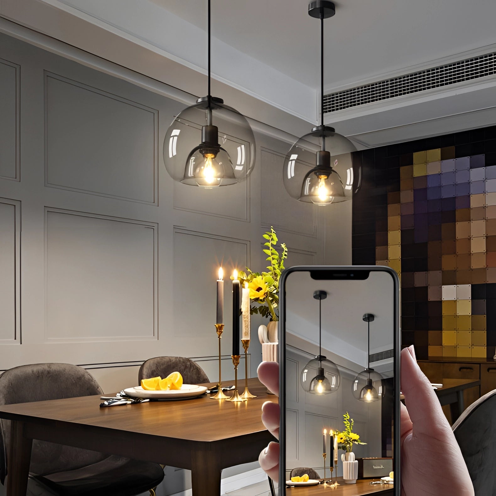 Modern clear glass pendant lights with stylish globe design hanging over a wooden table in a contemporary interior setting.