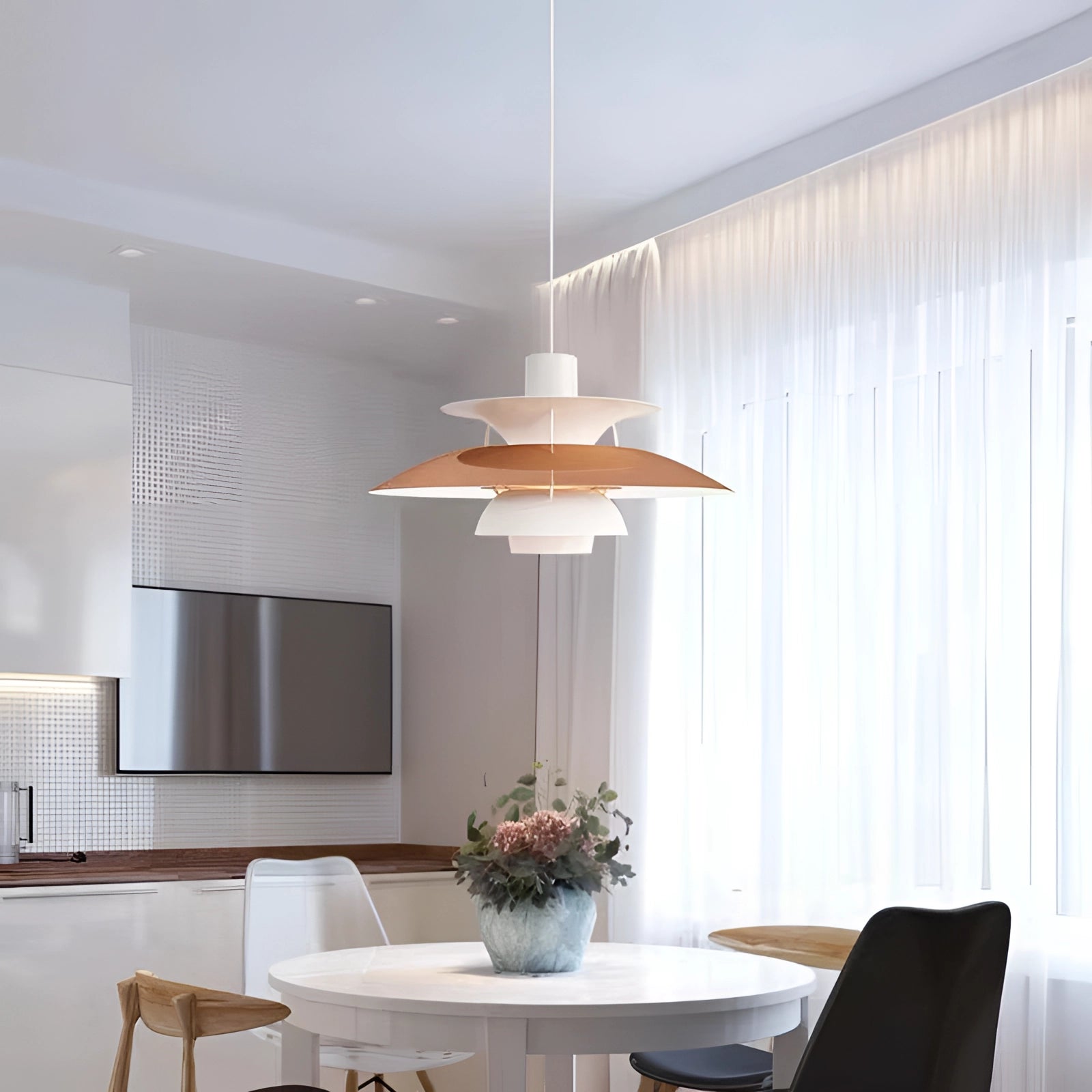 Modern colorful pendant lighting with a Scandinavian design, featuring a multi-tiered structure in shades of brown and orange, elegantly illuminating a contemporary interior with wooden furniture, a table, plants, and chairs.