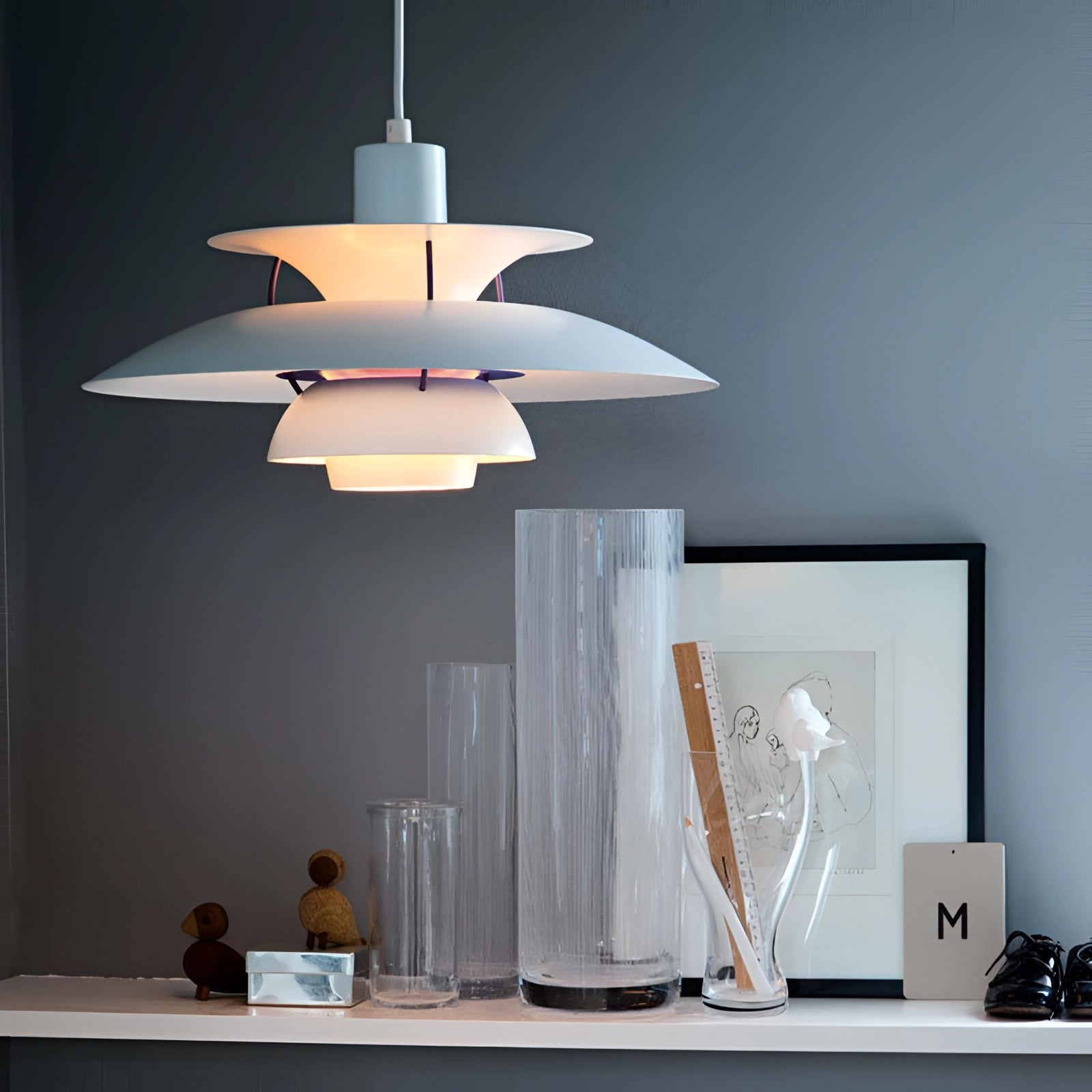 A modern, multi-tiered pendant light with a Scandinavian design featuring a colorful wooden structure hanging from the ceiling, complementing contemporary interior decor with its artistic and stylish appeal.