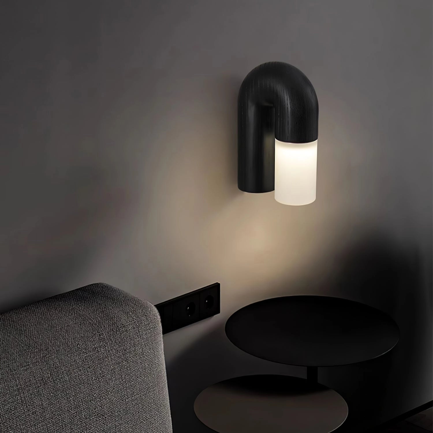 Modern curved wooden wall sconce with a sleek black finish, featuring a minimalist arch design and integrated LED lighting.