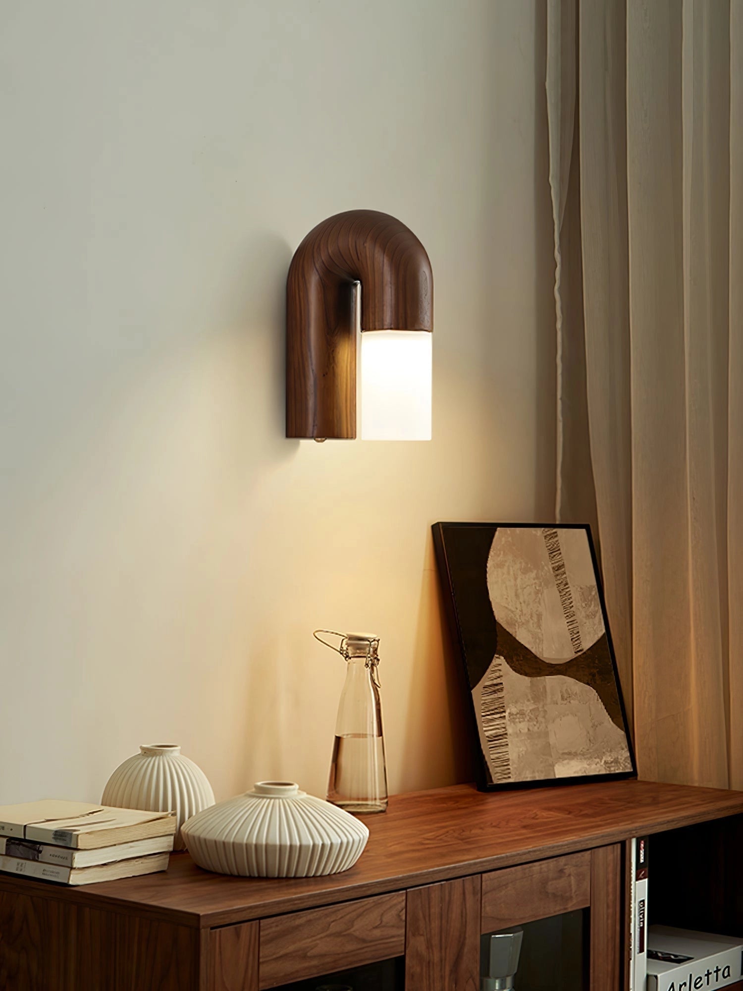 Modern curved wooden wall sconce with LED lighting, featuring an elegant arch design, mounted on a wall as part of minimalist interior decor.