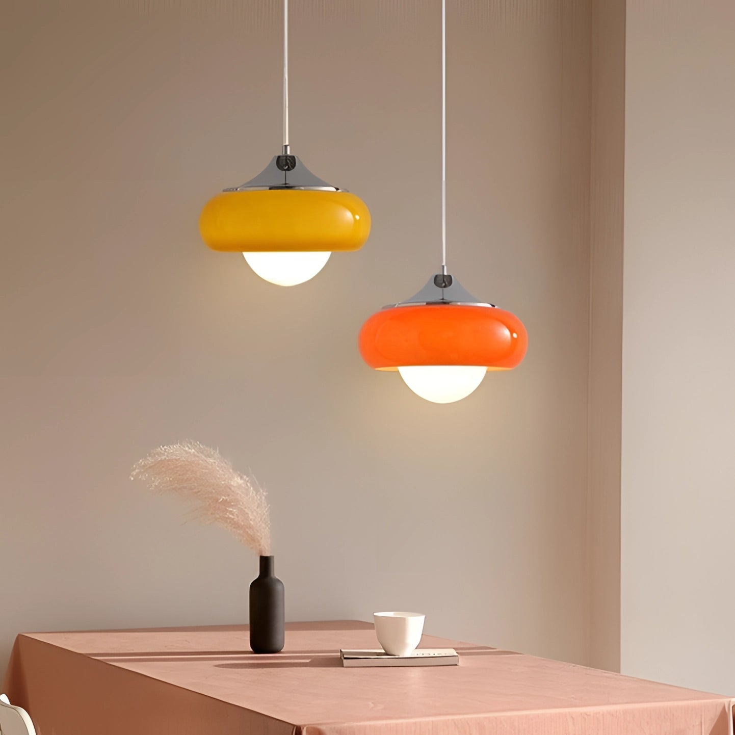 Modern dual color pendant lamps in Scandinavian mid-century style hanging from the ceiling, featuring a sleek design with wood accents and orange elements, illuminating a contemporary interior setting.