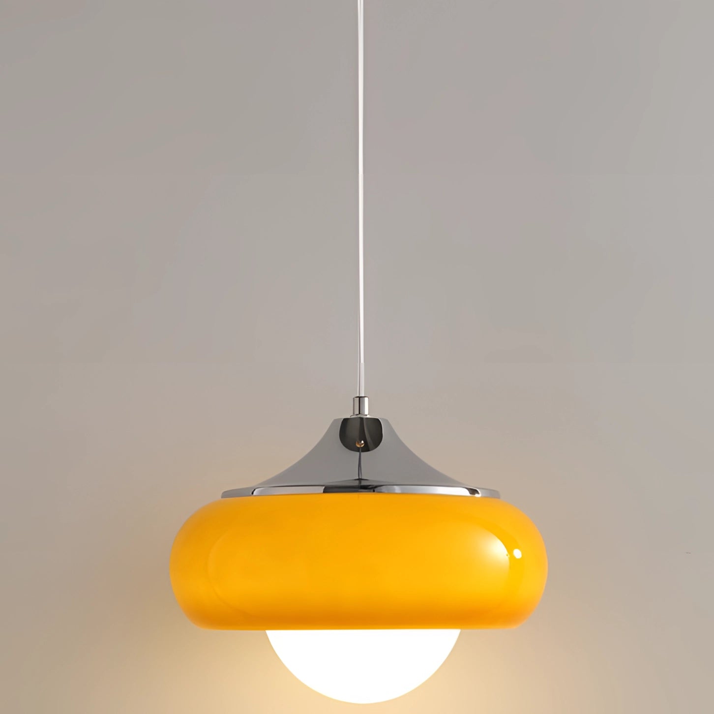 Amber-colored modern dual color pendant lamp in Scandinavian mid-century style featuring a circular and oval design with a metal and wood construction, suspended from the ceiling.