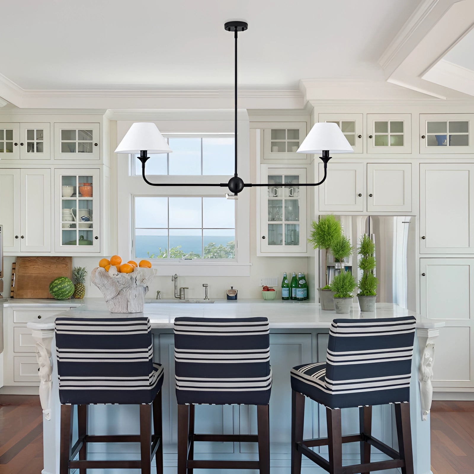 Modern Dual Lamp Black LED Chandelier hanging above a contemporary kitchen setting with wooden cabinetry and a countertop.