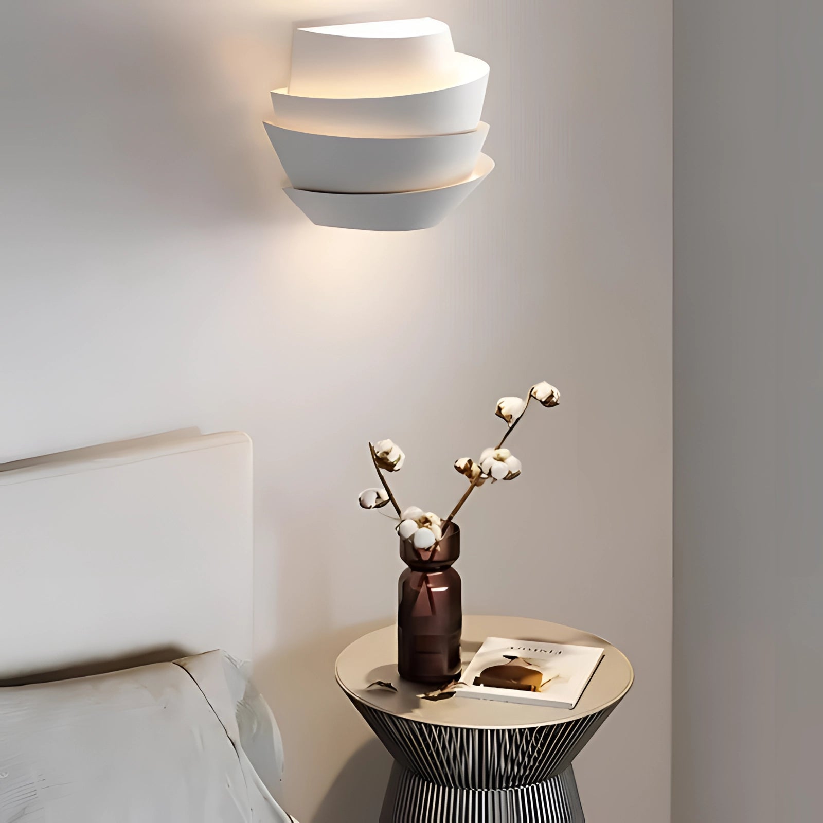 Modern floating lamp with minimalistic design and soft glow light, placed on a wooden table next to a vase with houseplants, creating a stylish interior design setting.