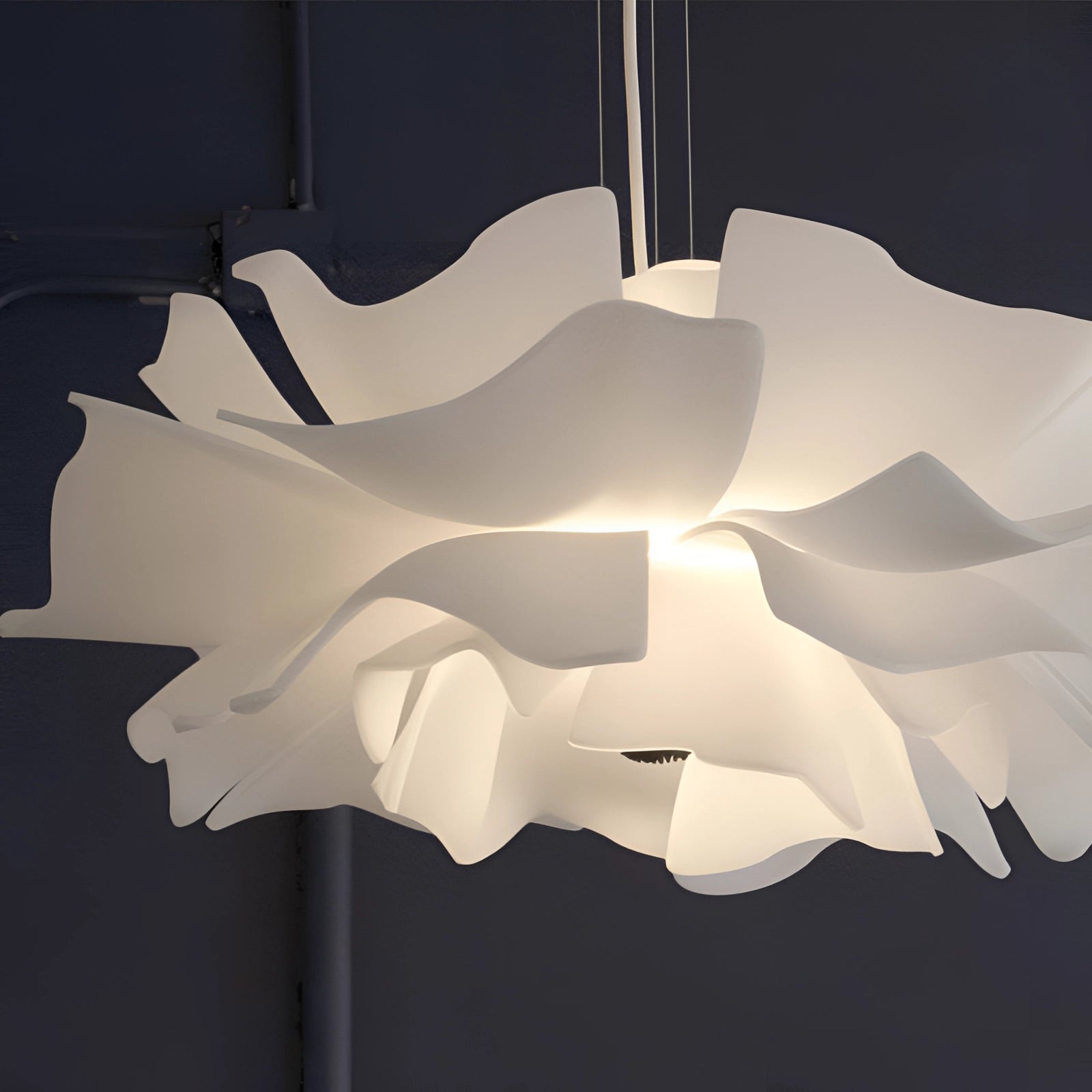 Modern flower-shaped pendant light with a designer floral chandelier, featuring intricate wooden patterns, symmetrical design, and artistic shades, suspended from the ceiling.
