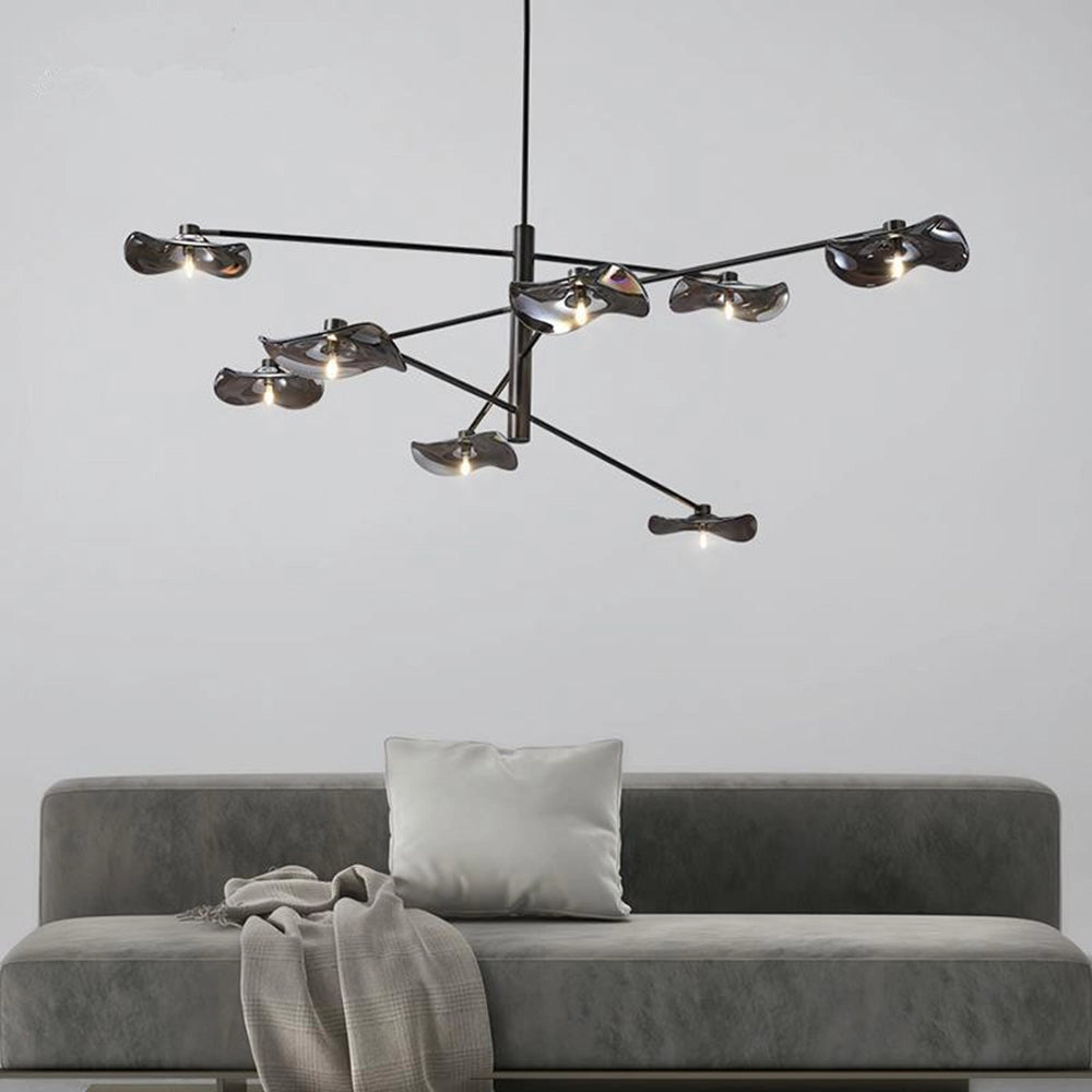 Modern geometric black and chrome multi-light chandelier with eight heads, suspended in a stylish living room setting featuring a grey couch and minimalist interior design elements.
