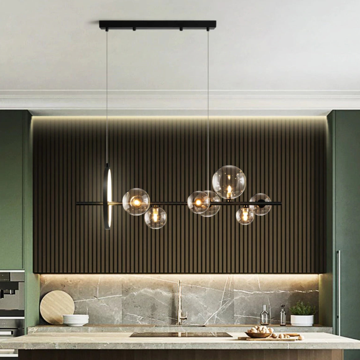 Modern geometric brass and glass chandelier hanging above a wooden countertop with sleek, rectangular design elements.
