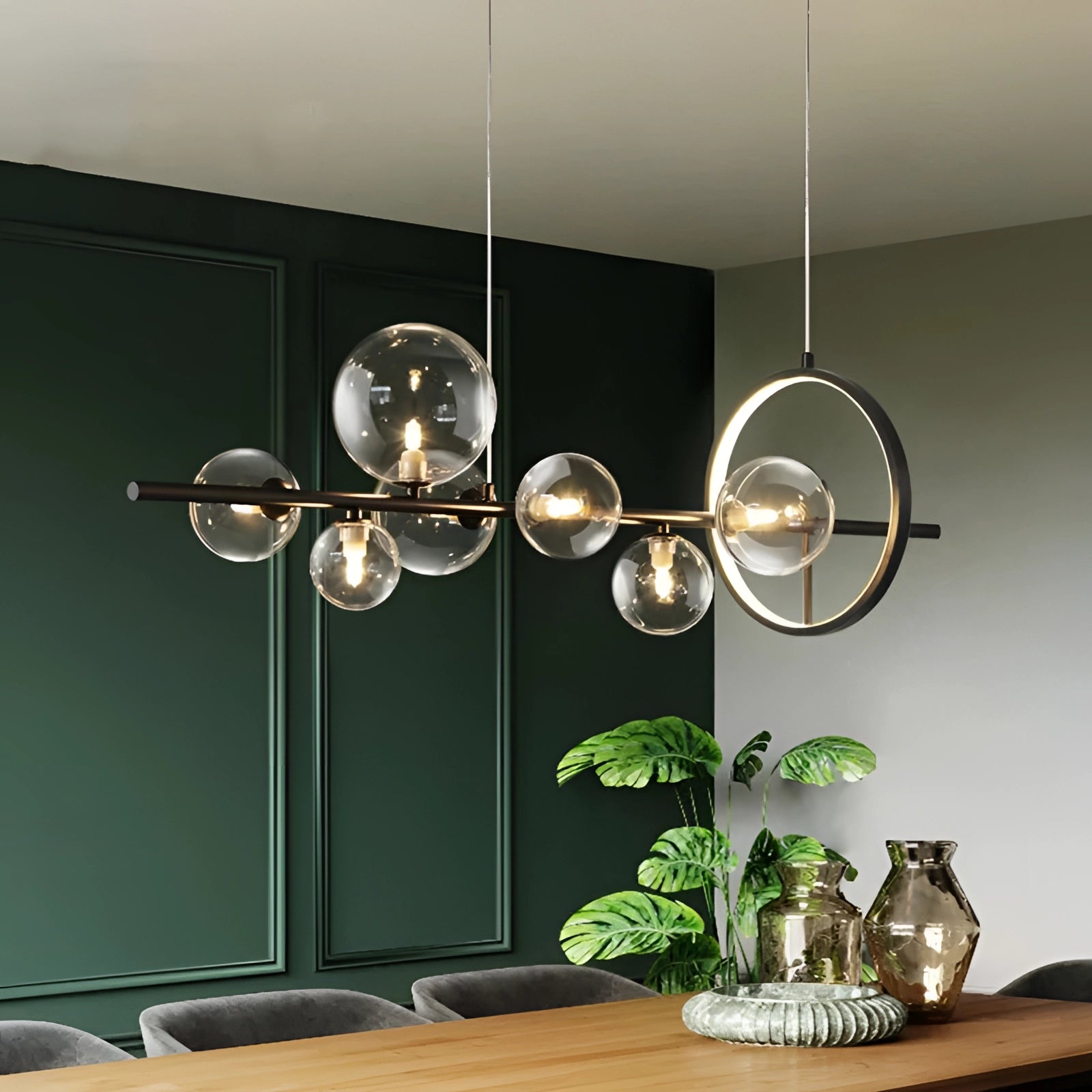 Modern geometric brass and glass chandelier hanging in a stylish room with a wooden table, potted plant, and elegant tableware.