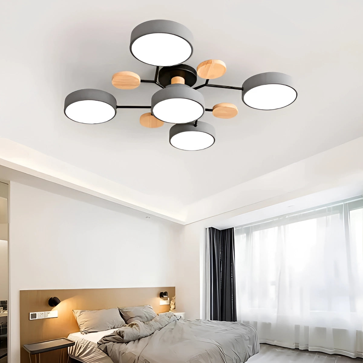 Modern geometric chandelier with a matte black frame and wood accents, featuring multiple bulbs and a gray color variation, hanging in a well-lit interior space.