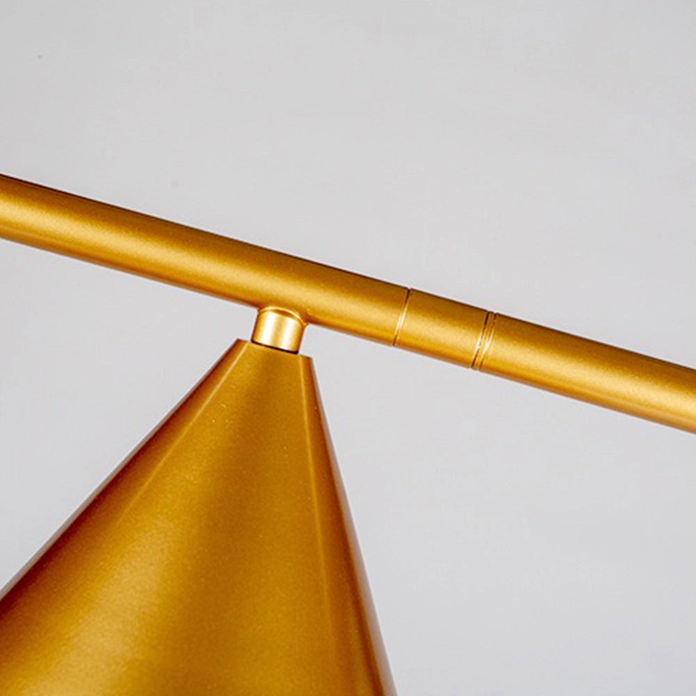 Modern geometric gold floor lamp featuring a minimalist design with a metal frame and triangular and circular shapes, complemented by an amber-tinted shade.