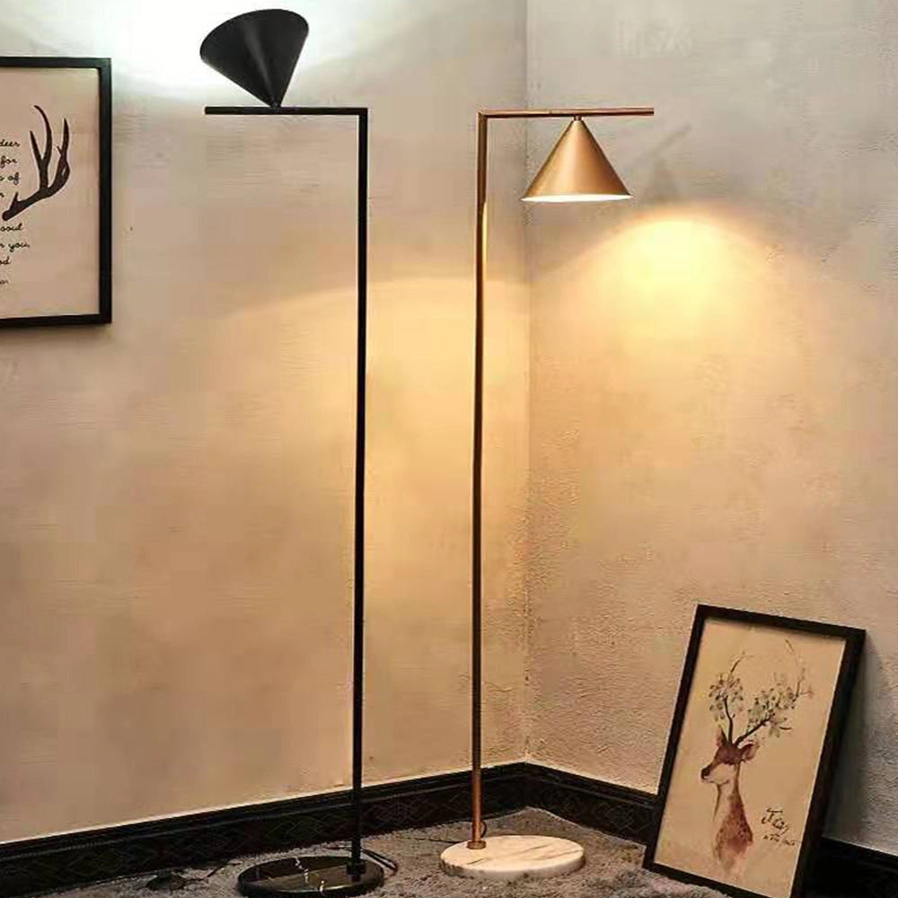 Modern geometric gold floor lamp with a minimalist design, featuring a sleek rectangular shape and amber lighting against a white and black background.