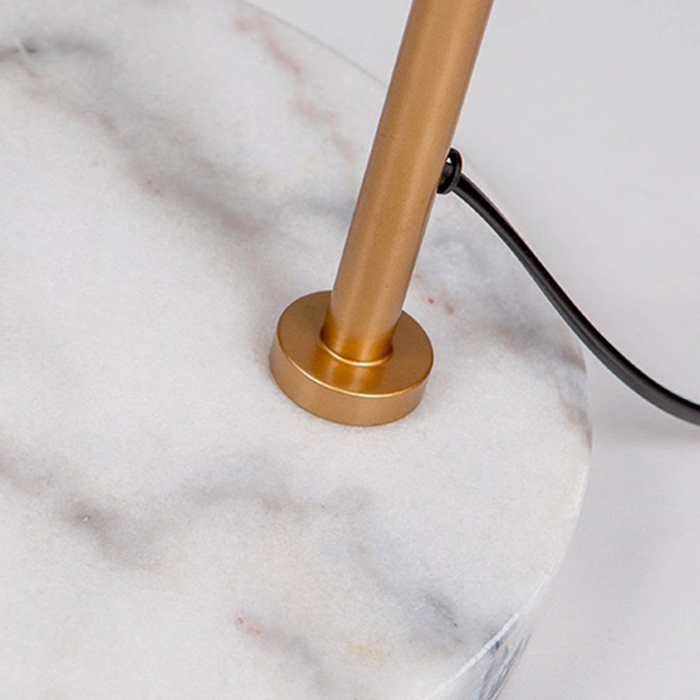 Modern geometric gold floor lamp with a minimalist design, featuring a circular metal base and slender pole crafted from a combination of metals, including nickel and aluminum, standing on a hardwood floor.
