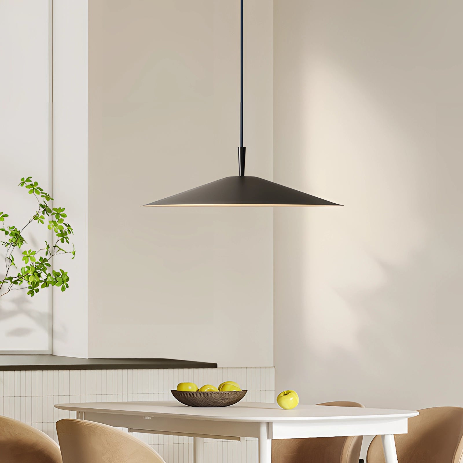 Modern black geometric LED pendant light with a minimalist design, suspended from the ceiling, illuminating a contemporary interior space with wooden elements and green plants.