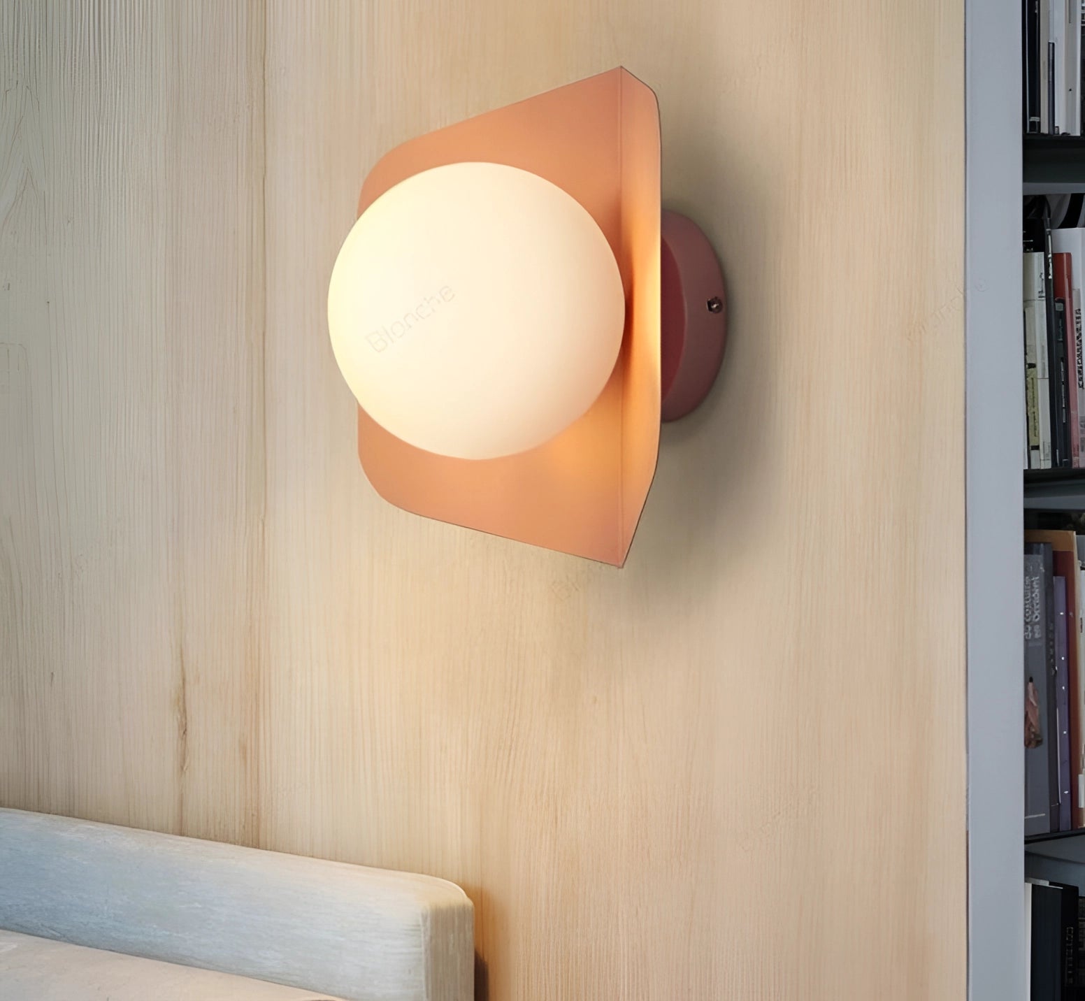 Modern geometric LED wall lamps in multi-color hexagonal fixtures mounted on a beige wall above a wooden bookcase with shelves.