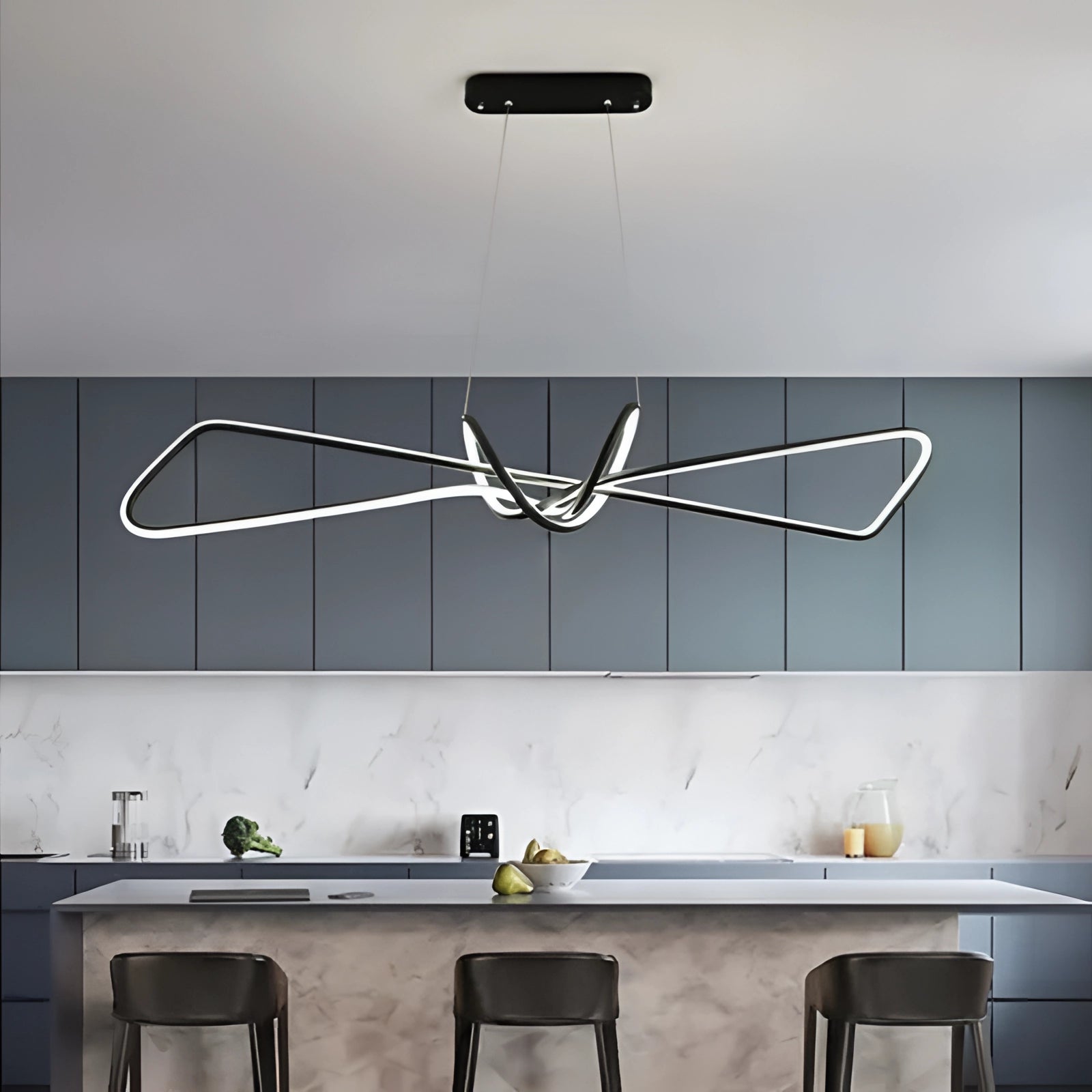 Modern black and white geometric pendant light hanging above a wooden table in a minimalist interior setting.