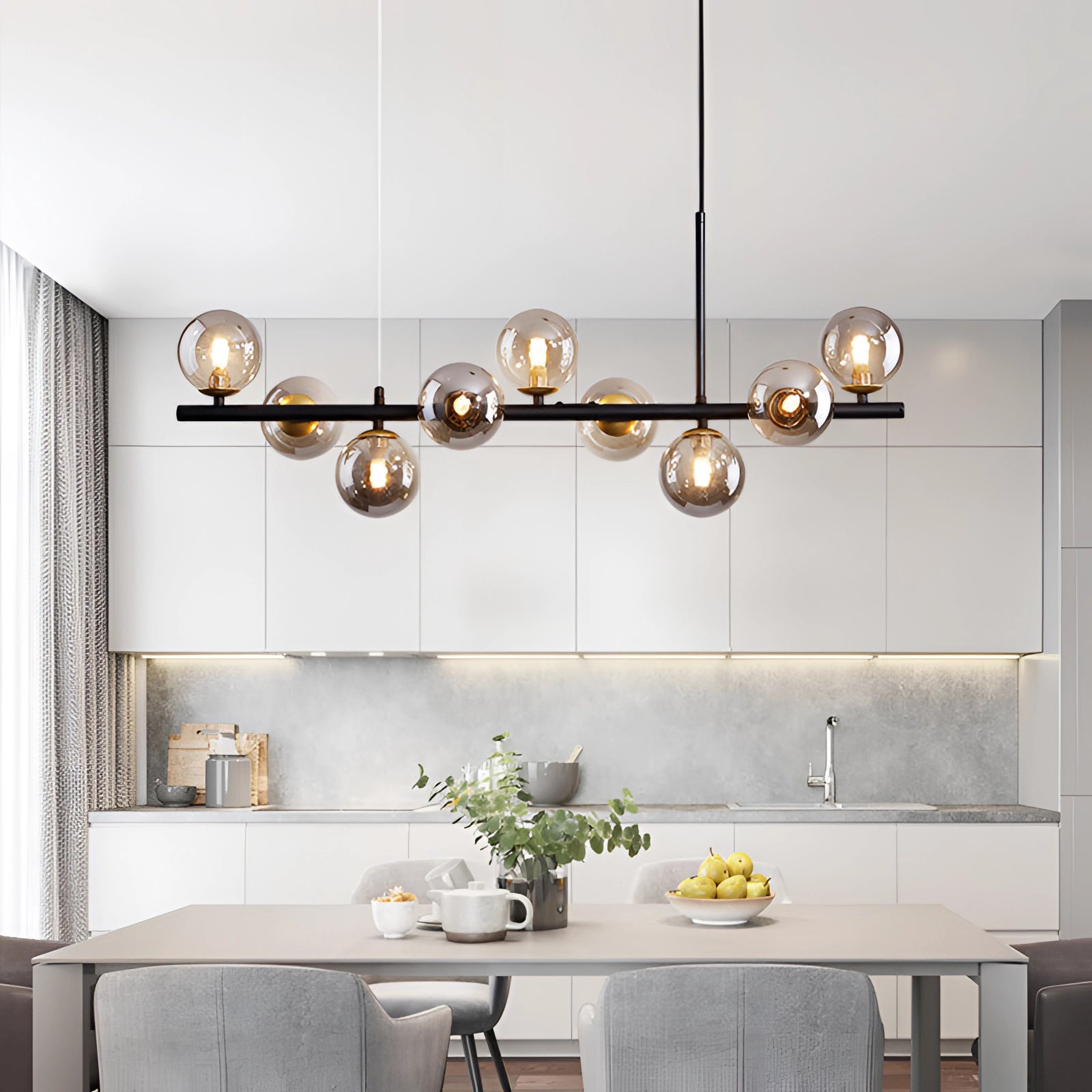 Modern glass globe chandelier with adjustable bronze pendant light illuminating a contemporary kitchen with white cabinetry, wooden countertops, and a sink with a tap.