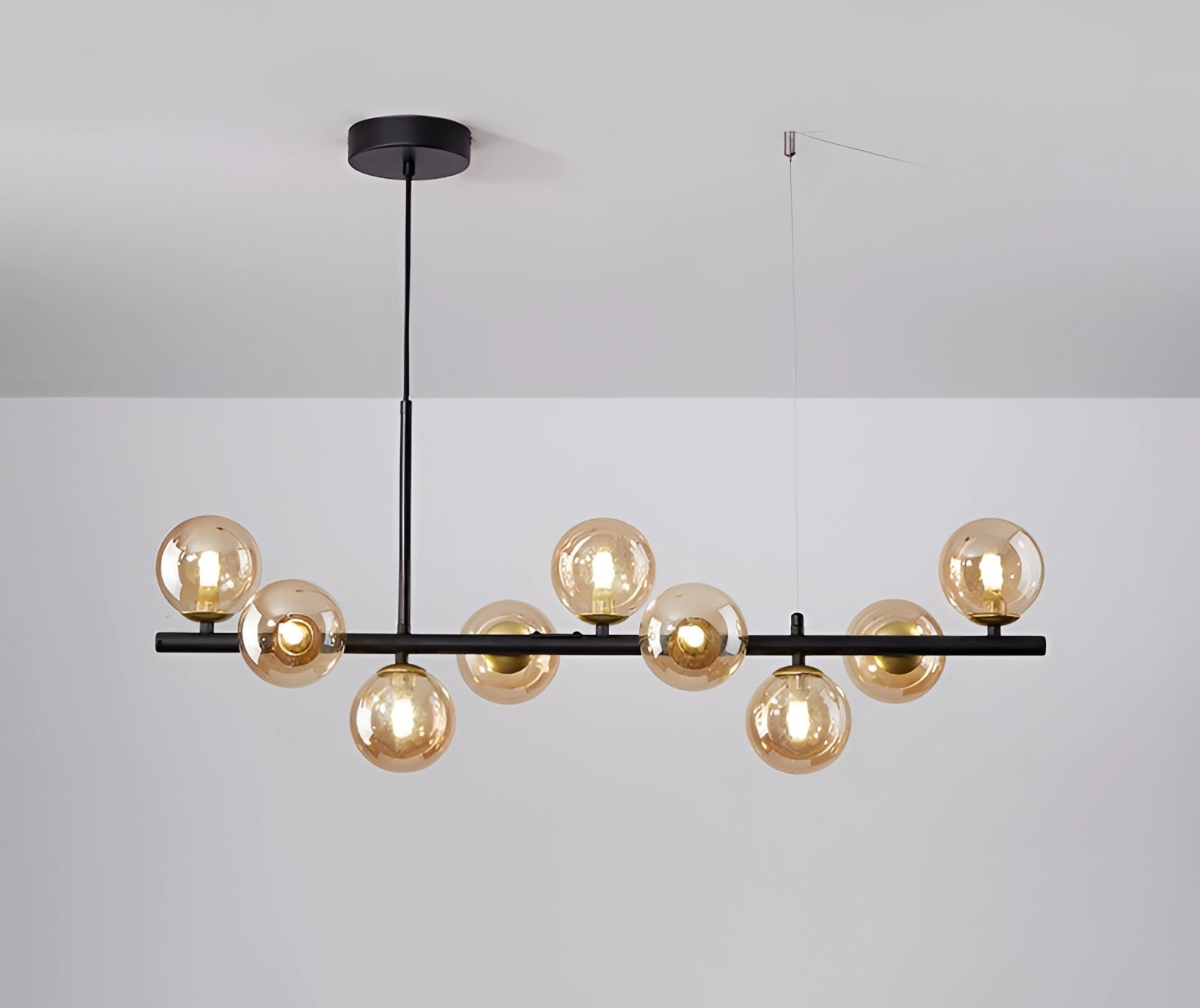 Modern Glass Globe Chandelier with Adjustable Bronze Pendant Light in Black-Cognac Color, featuring multiple spherical glass bulbs, suspended from a rectangular metal base.
