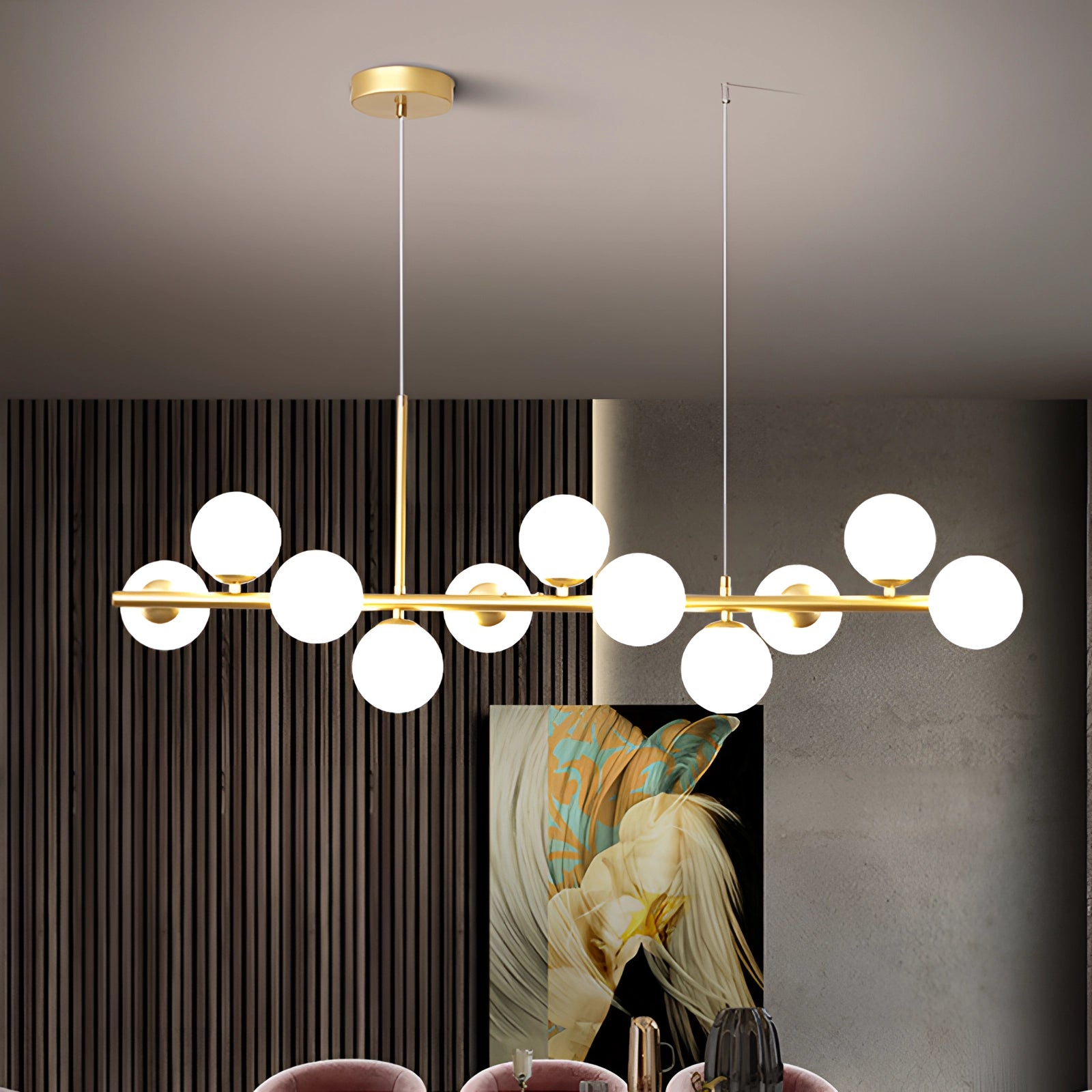 A modern glass globe chandelier with adjustable bronze pendant light fixture, hanging from the ceiling, illuminating a stylish interior design with nearby table and decorative plant.