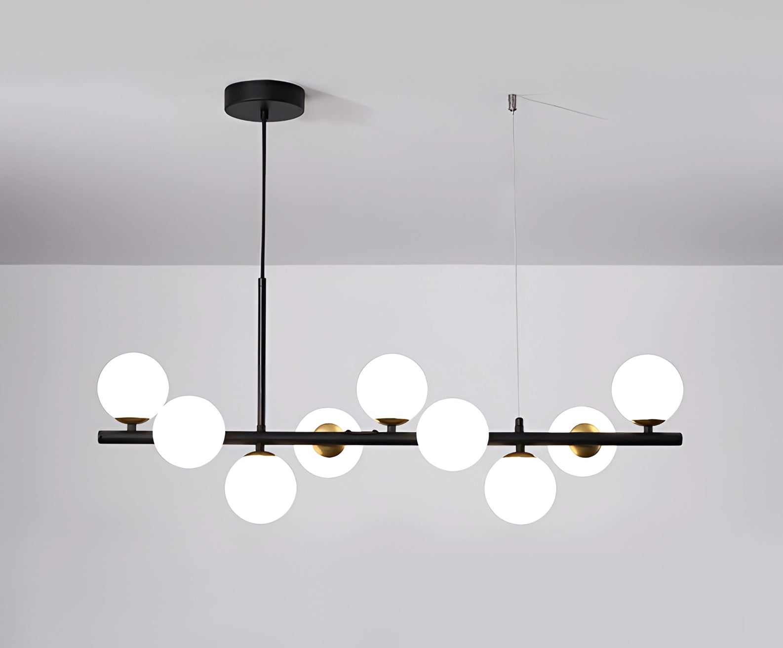 Modern glass globe chandelier with adjustable bronze pendant light, featuring black and white spheres, suspended from a ceiling.