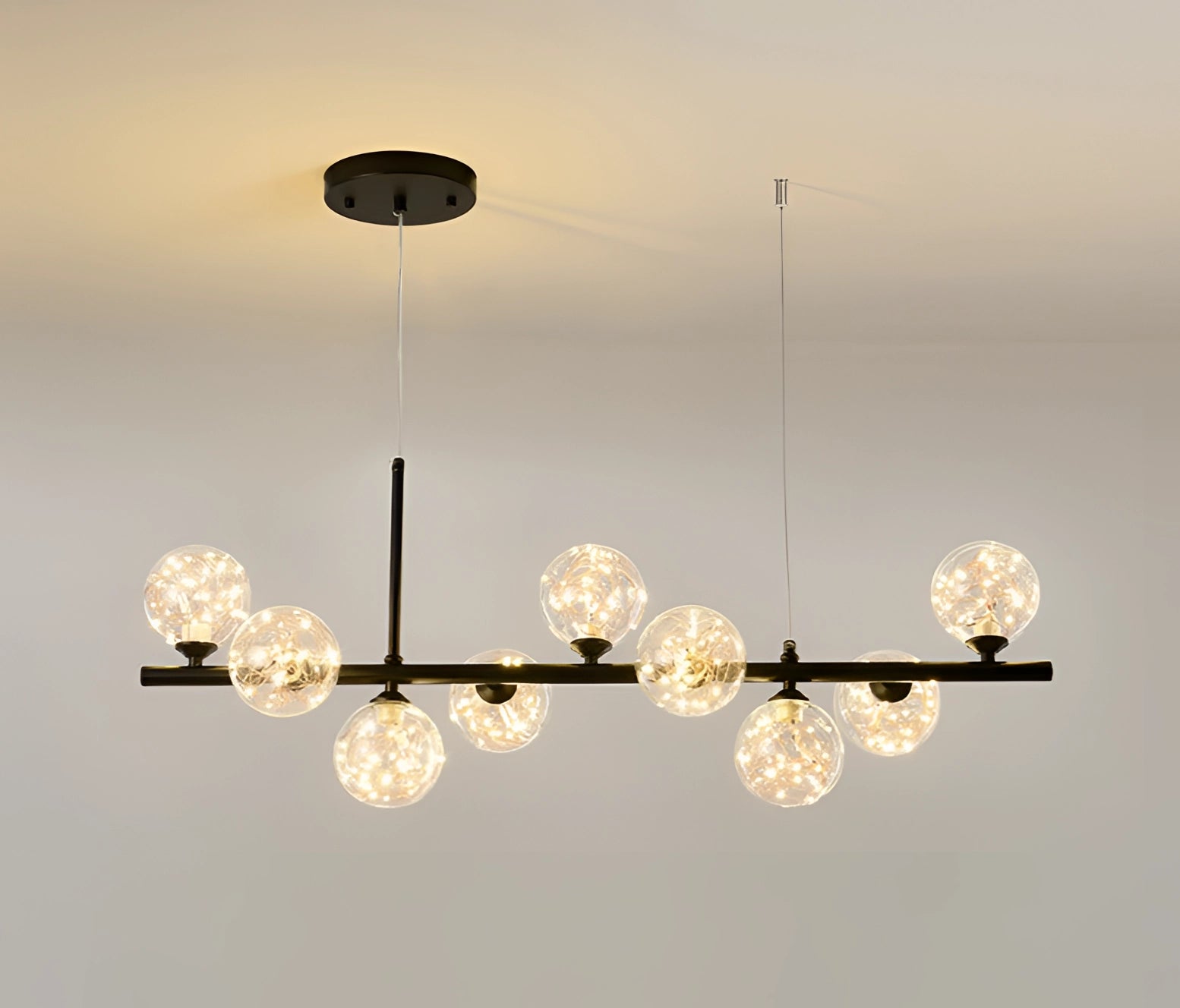 Modern Glass Globe Chandelier with Adjustable Bronze Pendant Light in Black Glittering Finish Hanging from Ceiling.