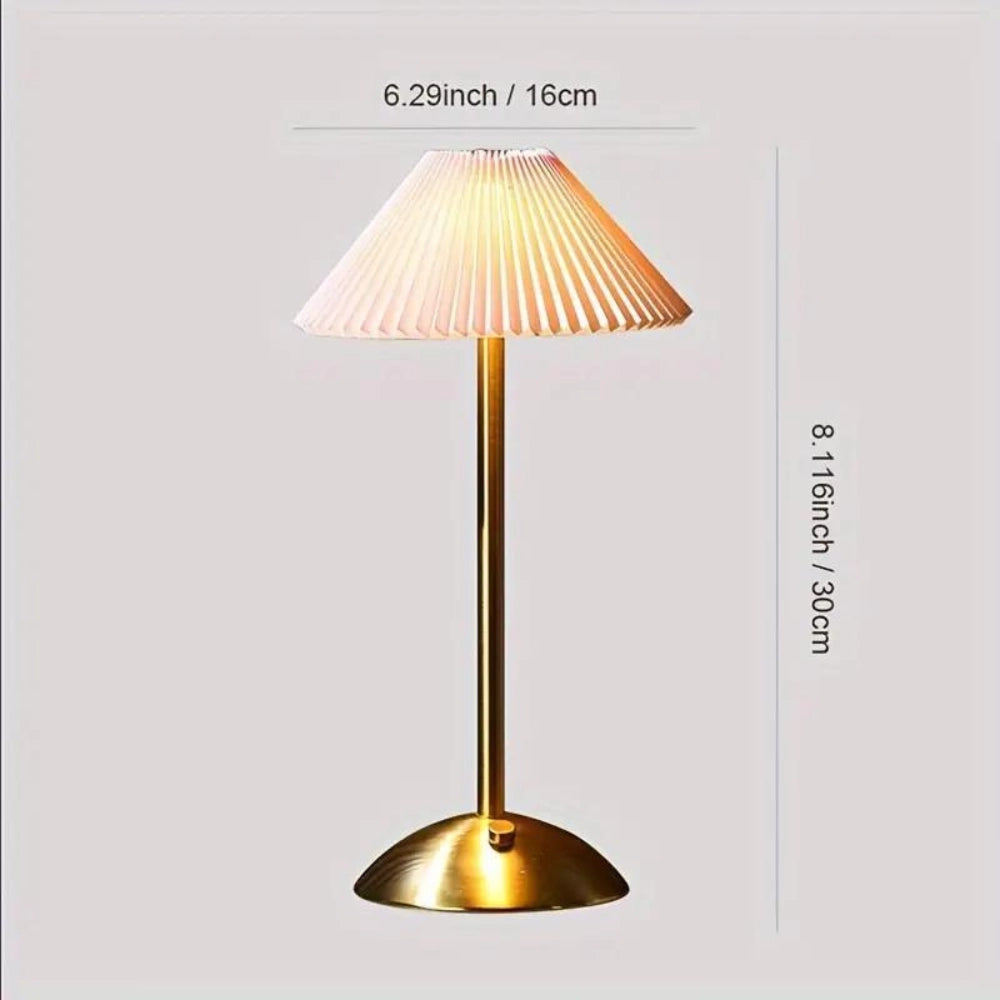 Modern gold base table lamp with an elegant ribbed pleated lampshade, featuring a warm peach tint and stylish design, suitable for enhancing any interior space.