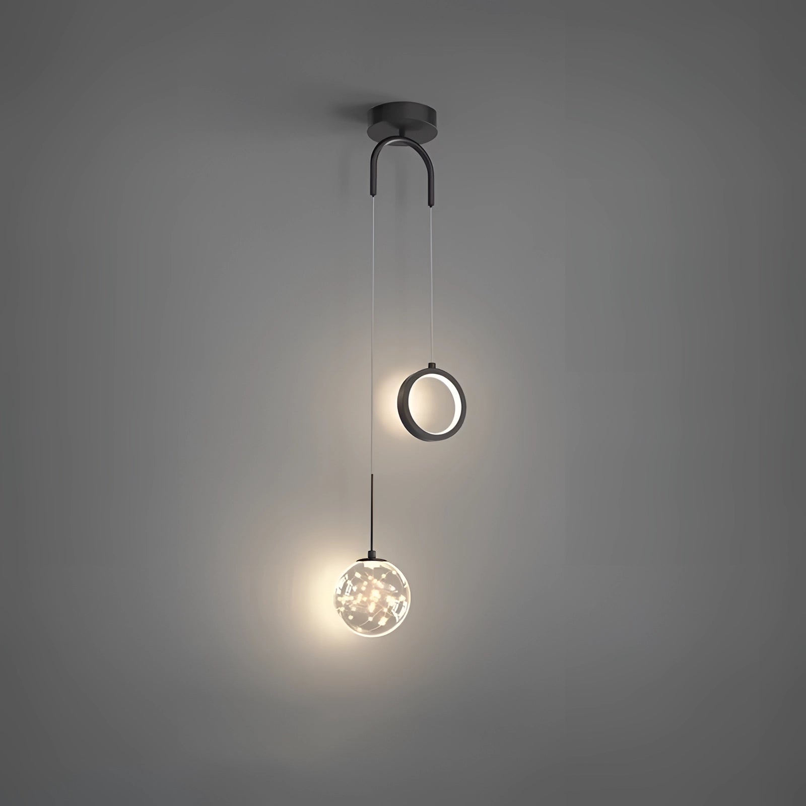 Modern gold dual pendant light with a sleek black ceiling fixture, featuring adjustable hanging lengths and circular transparent shades.