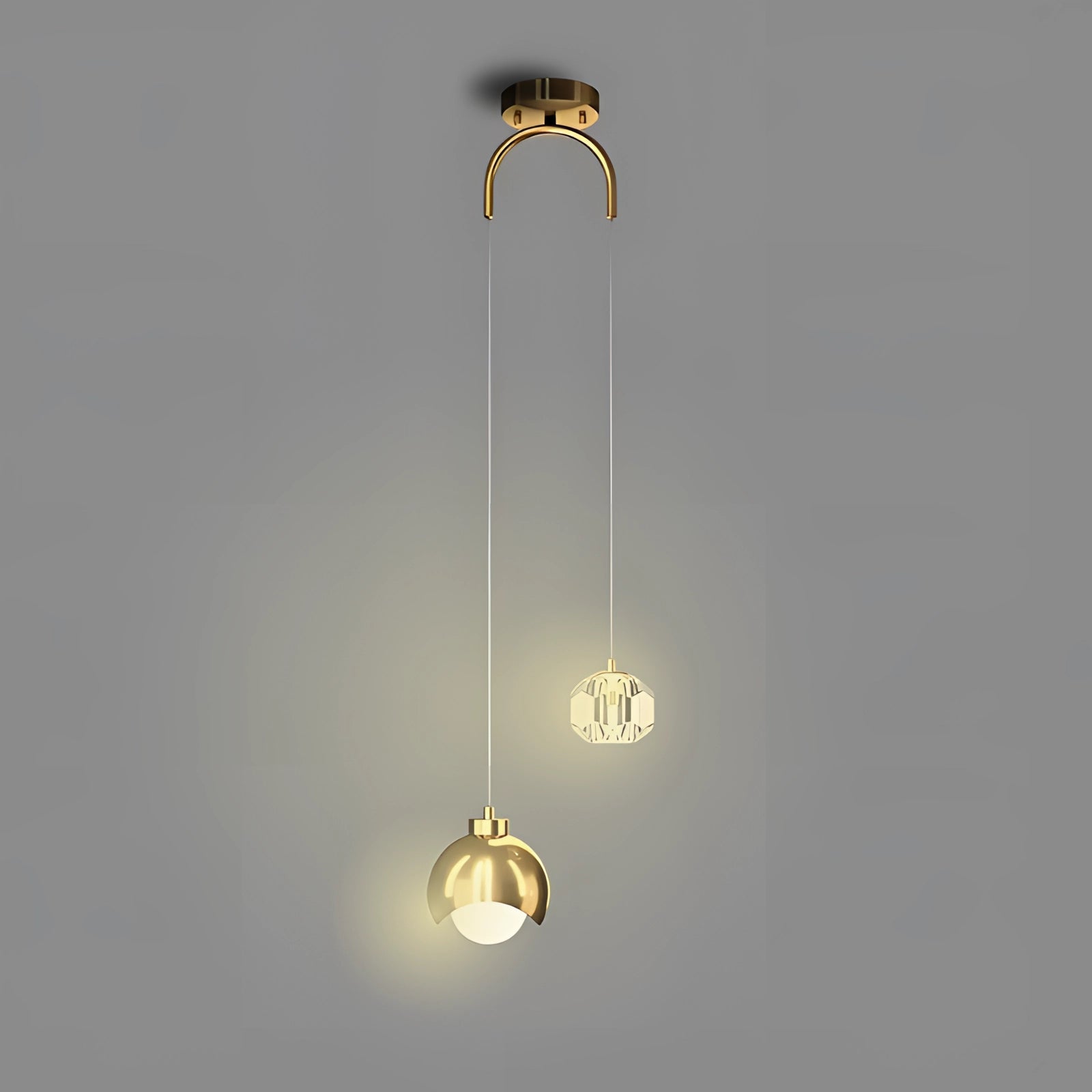 Modern gold dual pendant light with adjustable cords, featuring stylish circular shades hanging from a ceiling fixture, shown against a clear background.