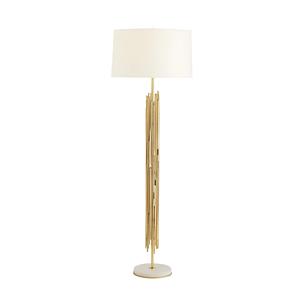 Modern gold floor lamp with white shade featuring elegant vertical rods, placed in a stylishly designed interior.
